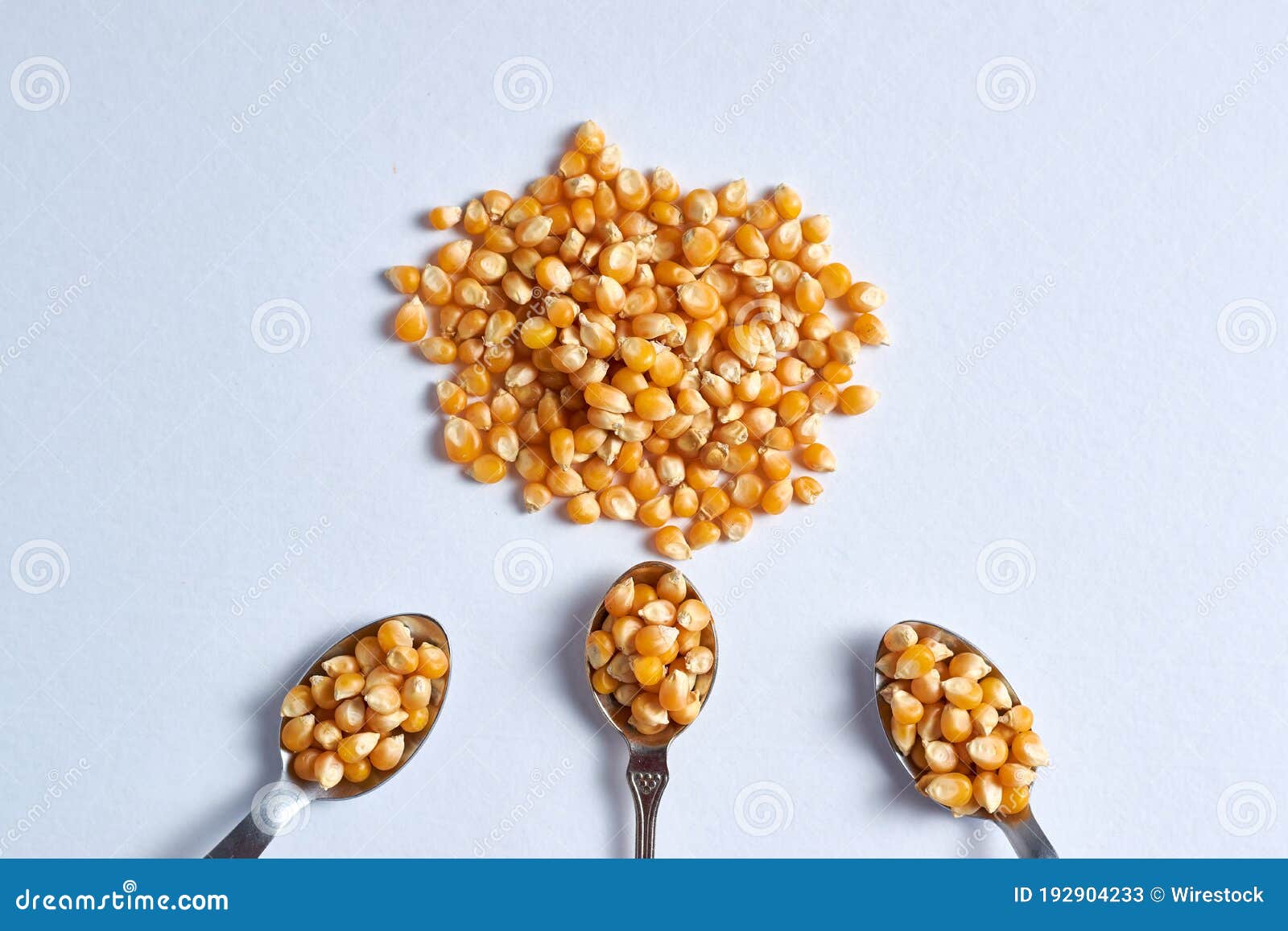 Top View Closeup Shot of a Pile of Corn Kernels with Three Spoons Also
