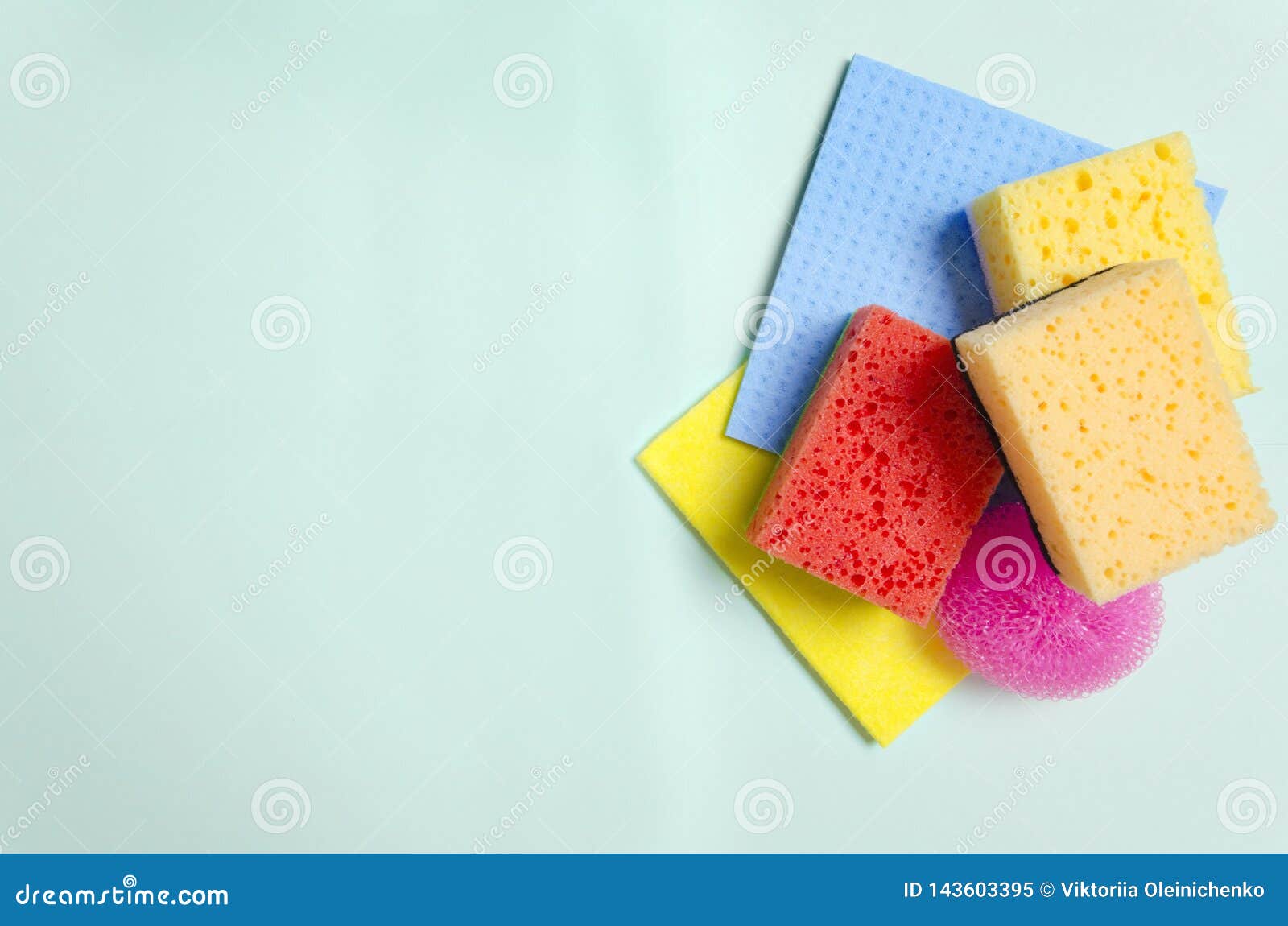 top view of different wash sponges on green surface.empty space for your .concept of pleasure of cleaning by using colorful