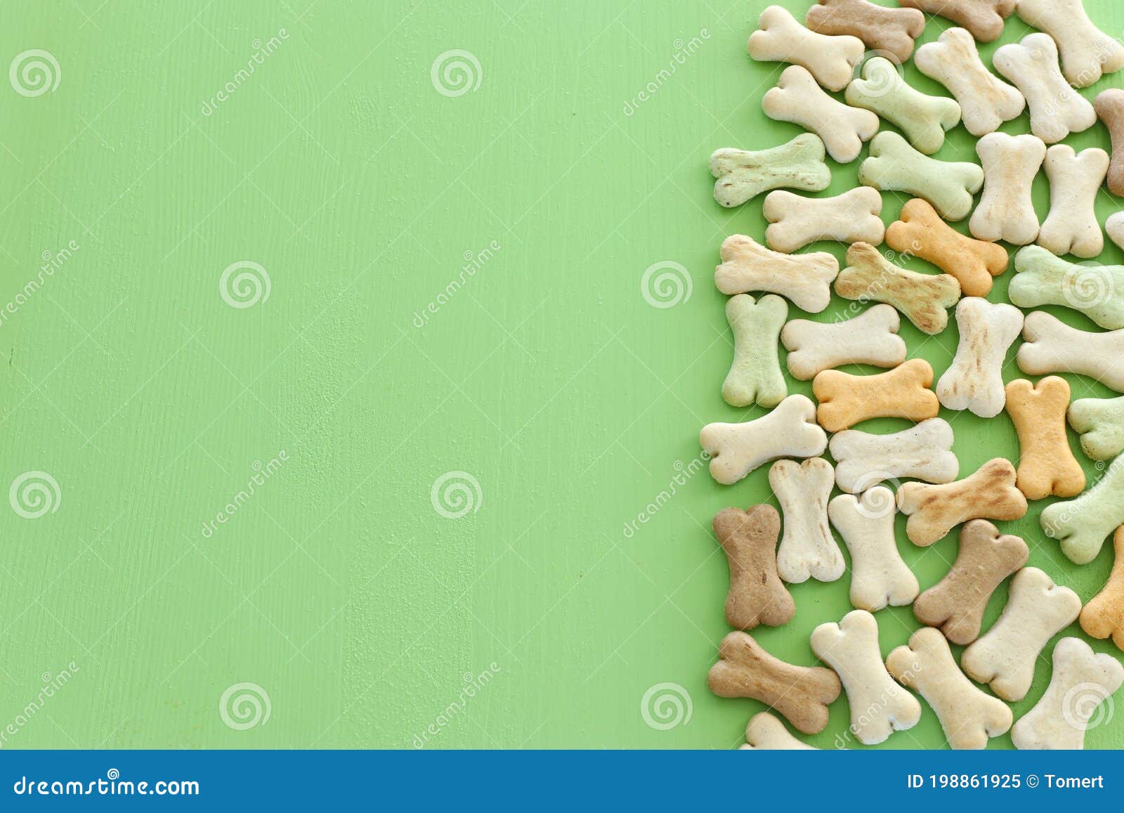 top view of dog treats over green wooden background