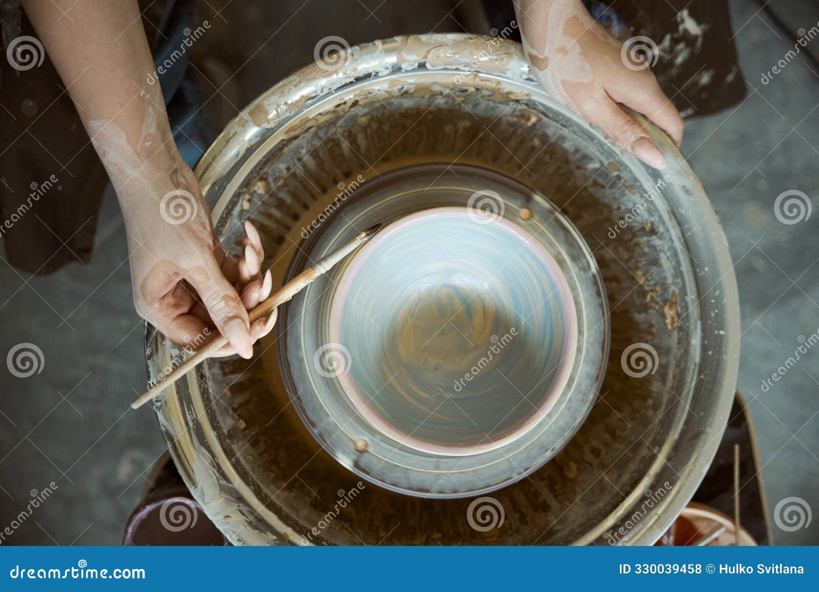 top view of female ceramist making clay pottery on a spin wheel in studio