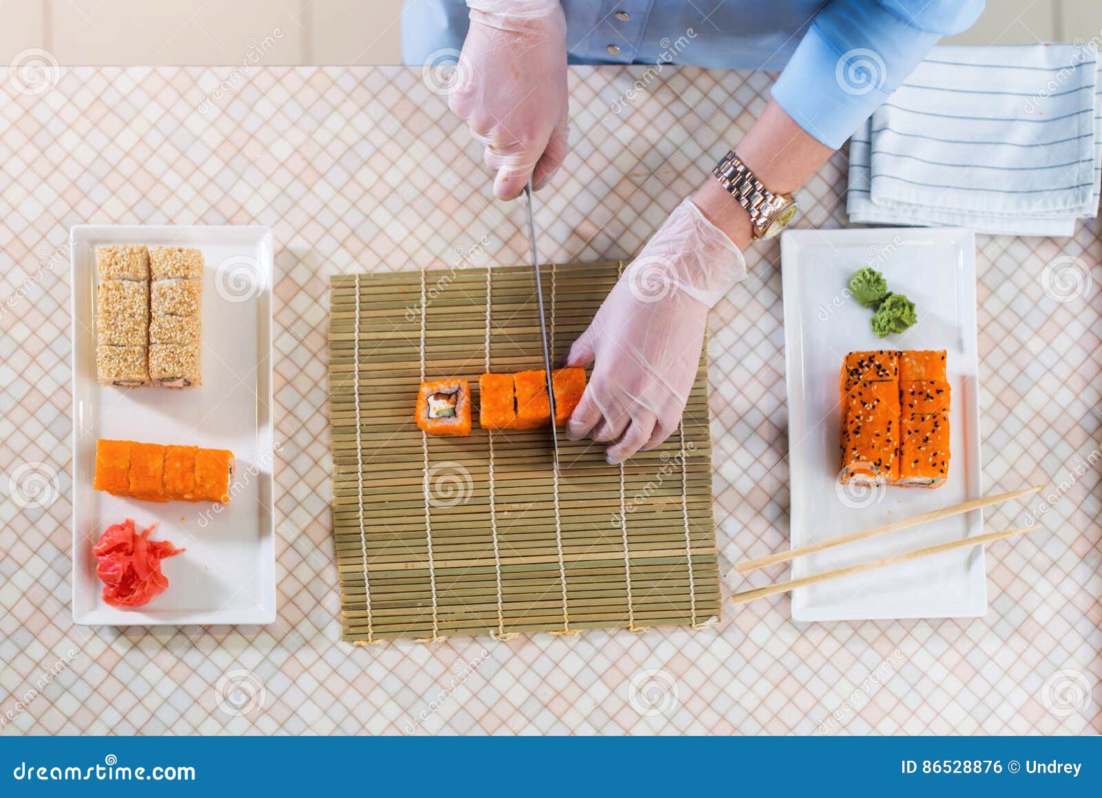Top View of Female Chef Working in Gloves Making Sushi Rolls in
