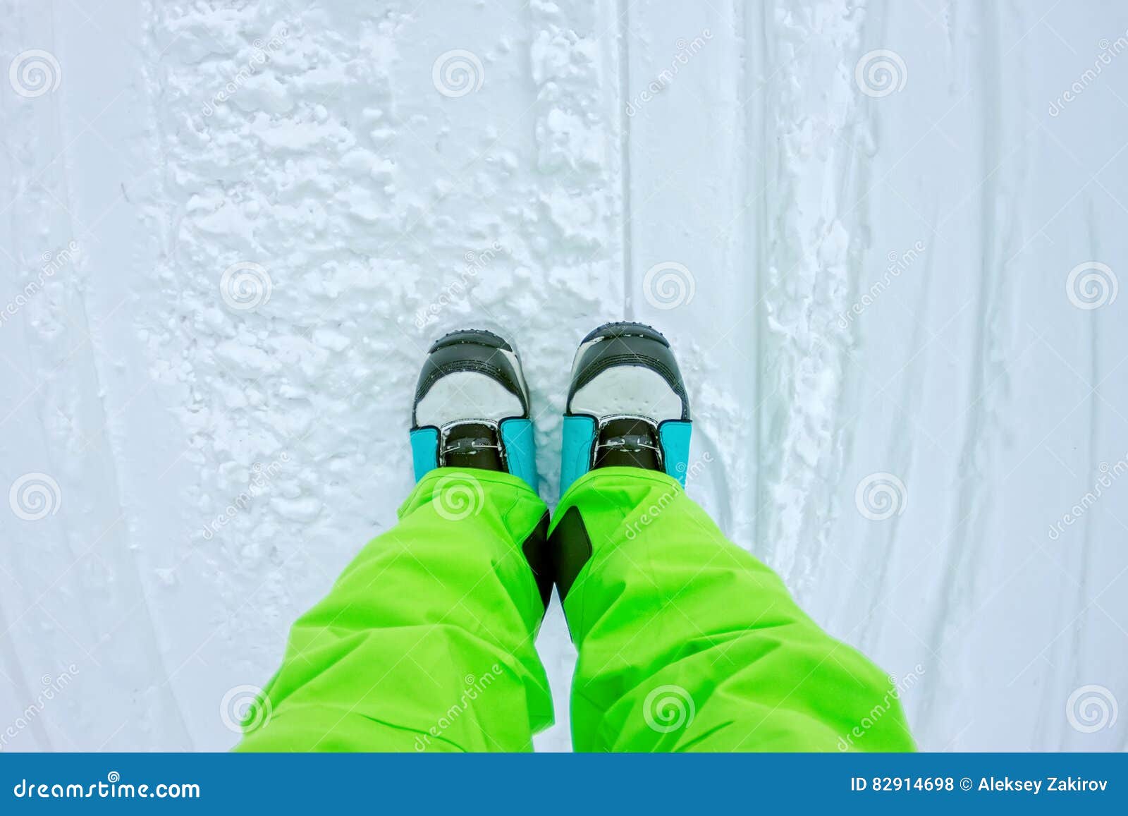 Top View of a Foot in the Snowboard Boots and Bright Pants Stock Photo