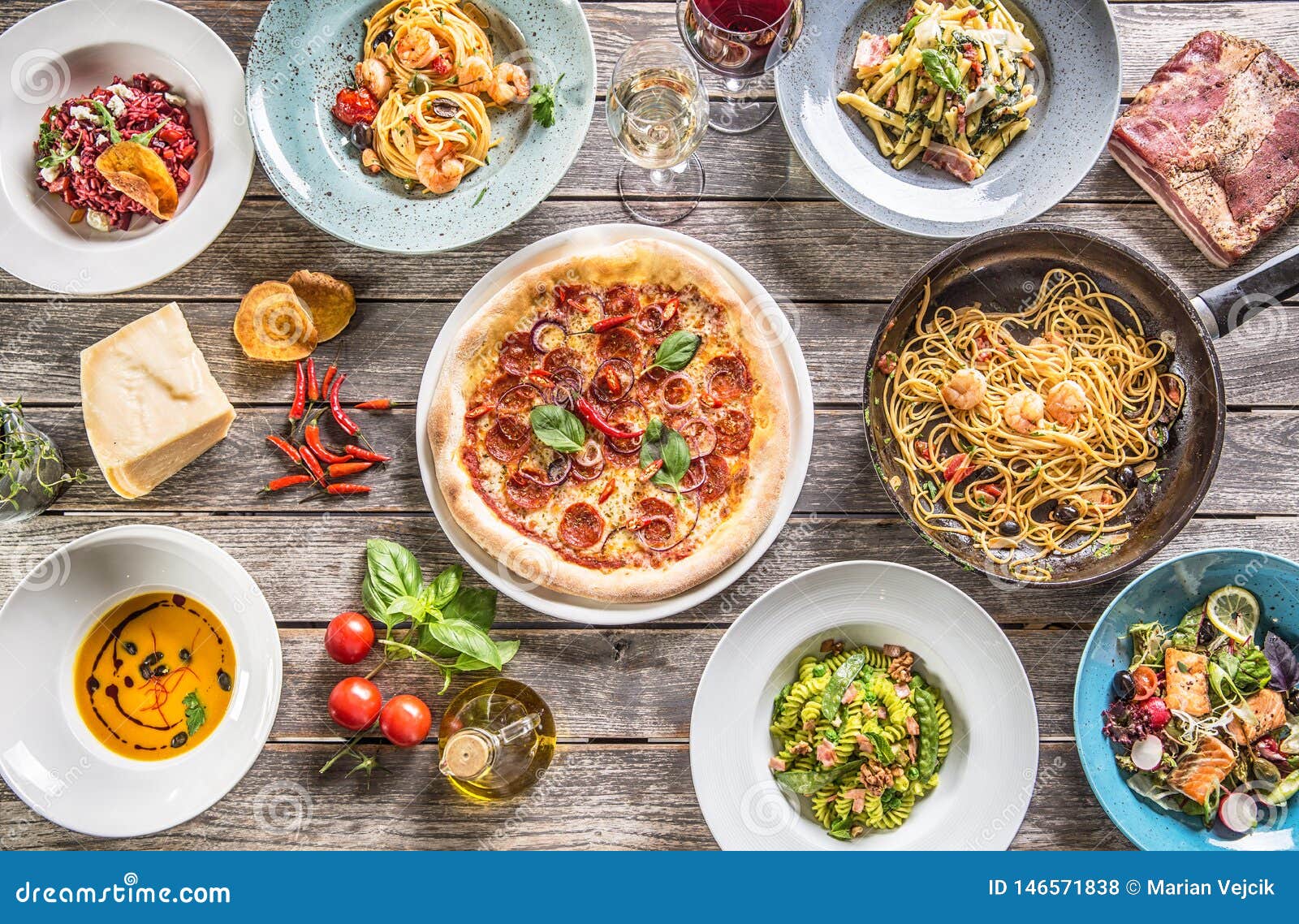 Top of View Full Table of Italian Meals on Plates and Pan. Pizza Pasta Risotto Soup and Fish
