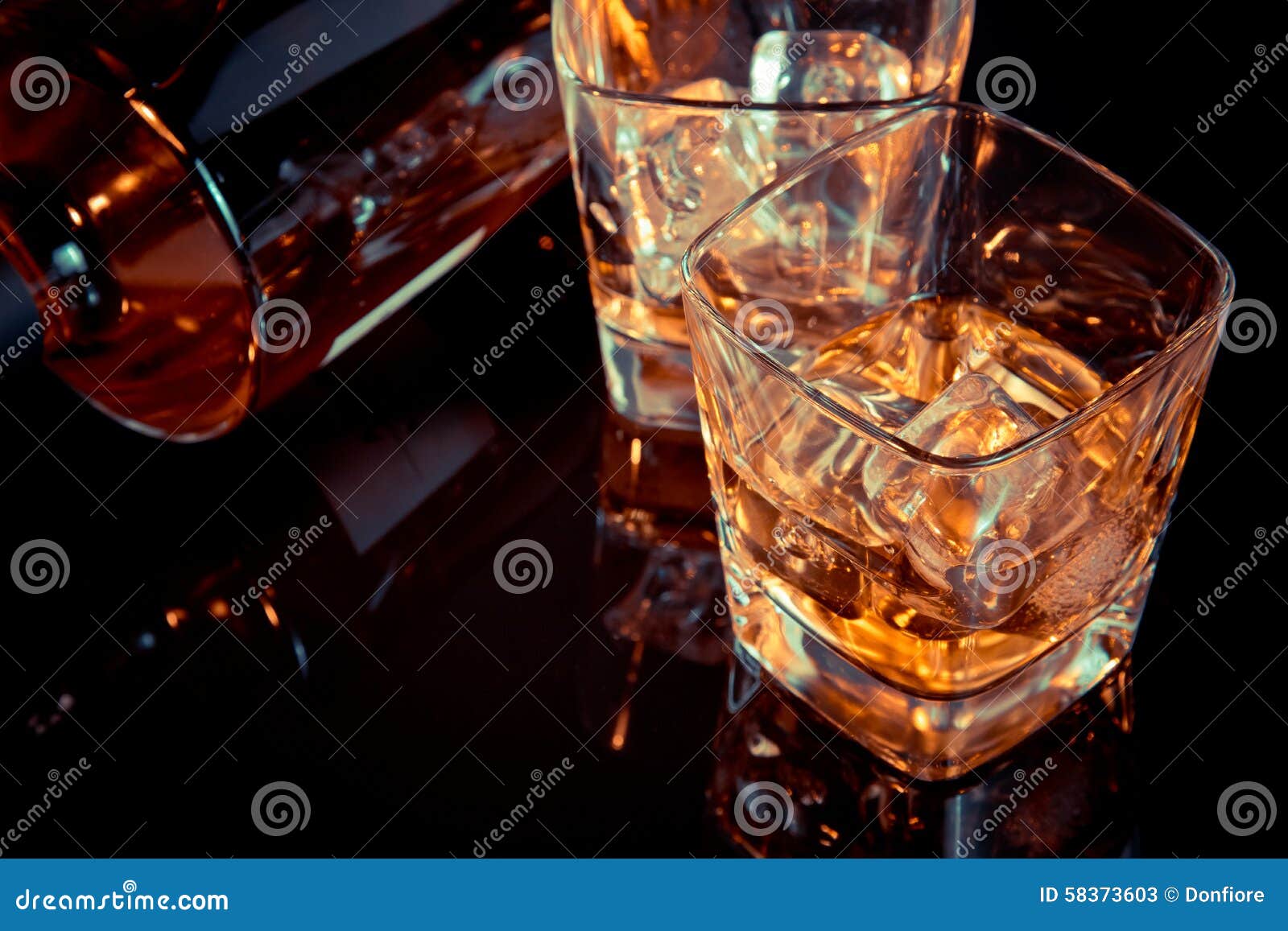 Premium Photo  Ice ball in glass of whisky on a reflective black table.