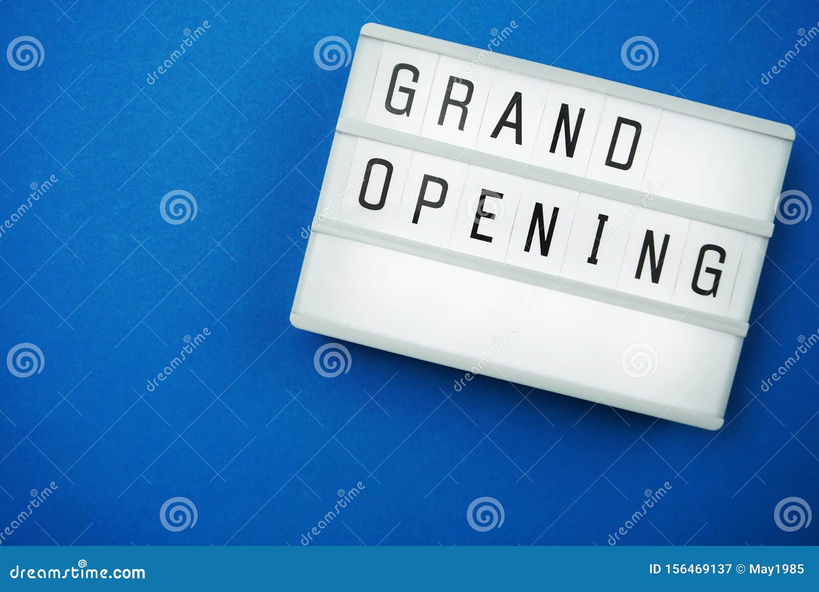 Grand Opening Word in Light Box Flat Lay with Space Copy on Blue