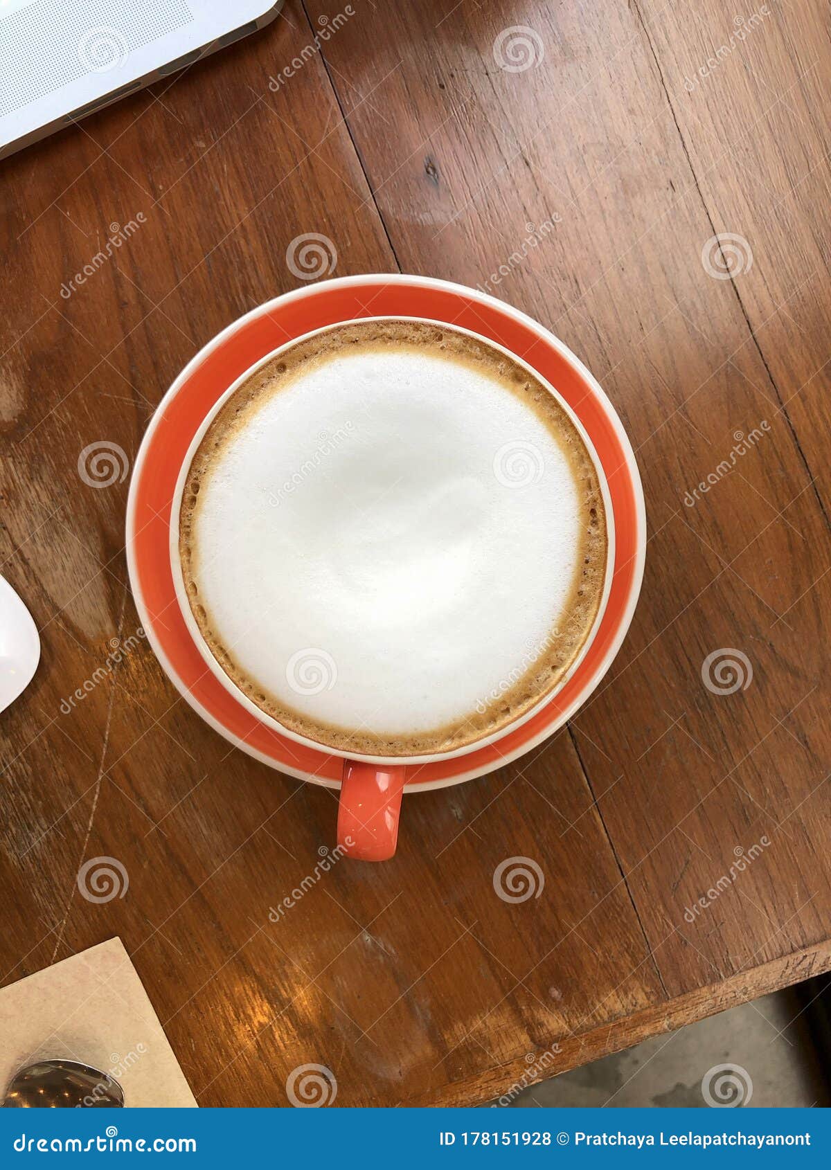 top view of hot cappuccino with milk foam on wood table in coffee shop