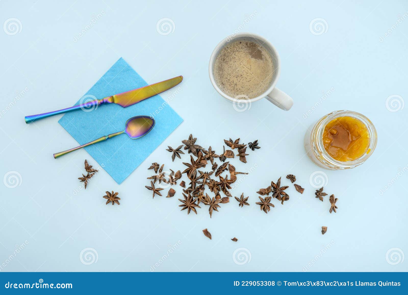 top view image of cafe con leche, a jar of bitter orange jam, dried aniseed