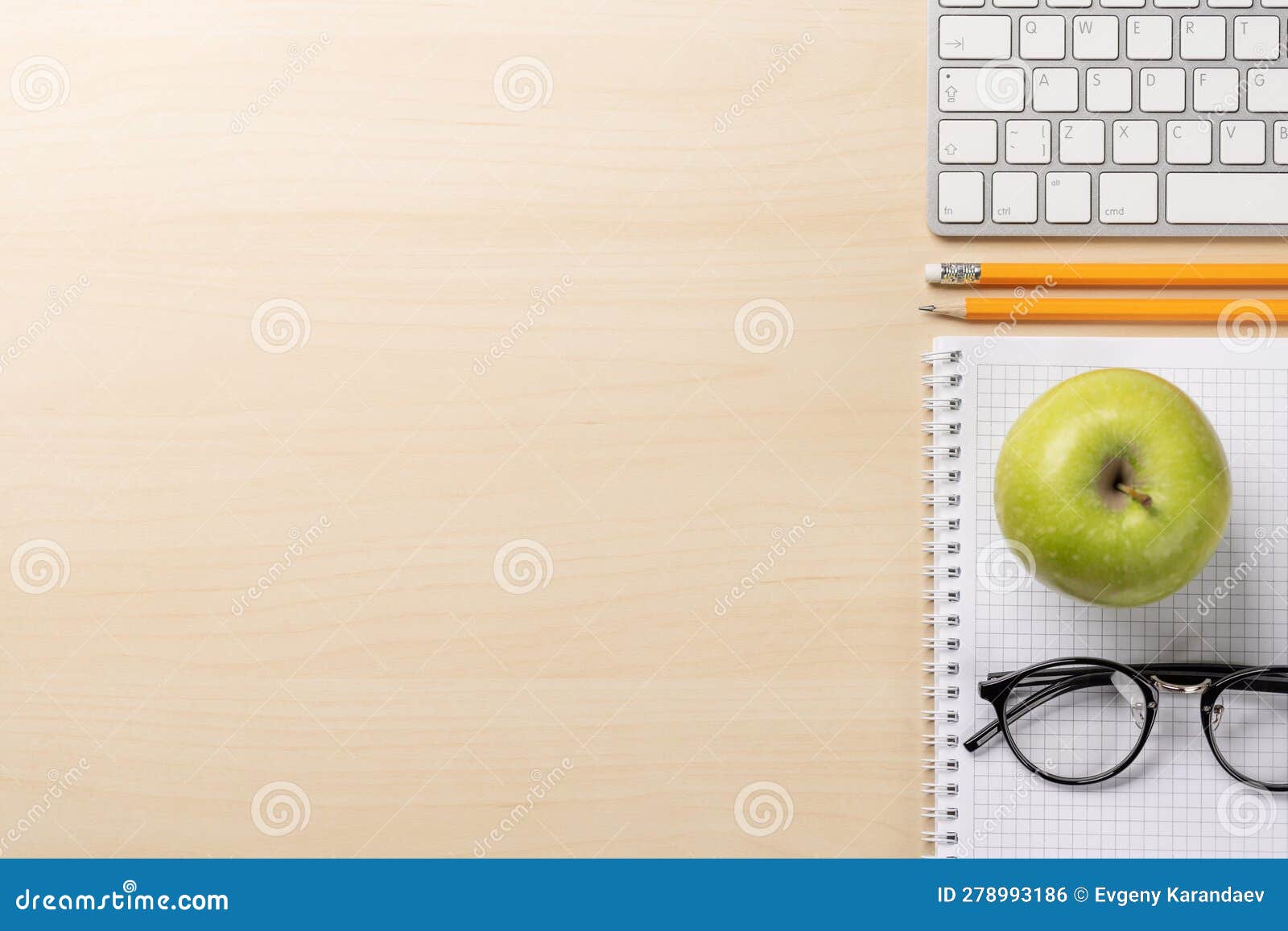 Top View of Keyboard, Notebook, Glasses, Pencils, Apple Stock Photo