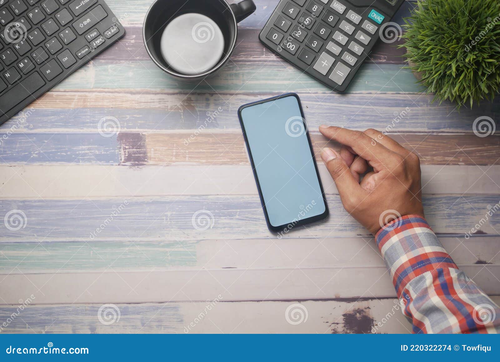 top view of man hand using smart phone on office desk