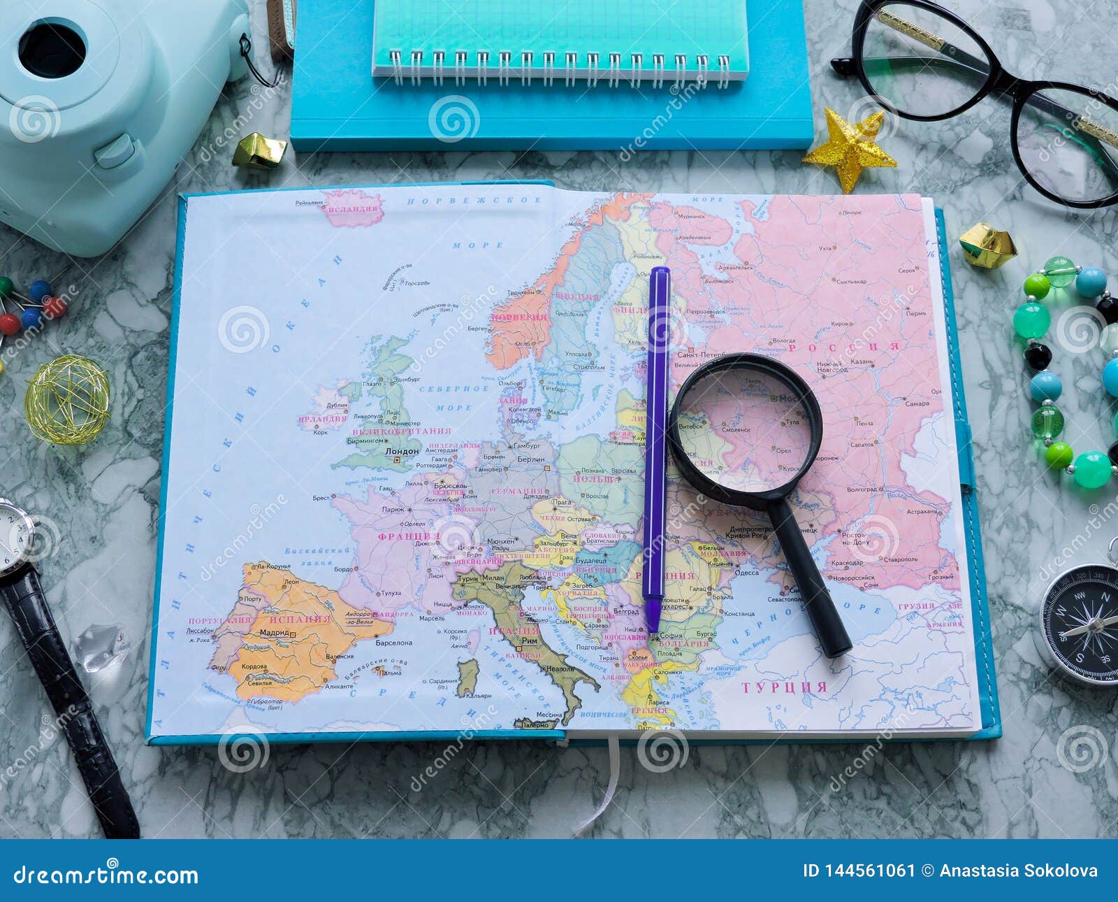 Top View of a map and items. Planning a trip or adventure. Travel planning dreams. Map of the world. Travel, tourism and vacation concept background. Stylish notebook, map and magnifier. Flat lay.