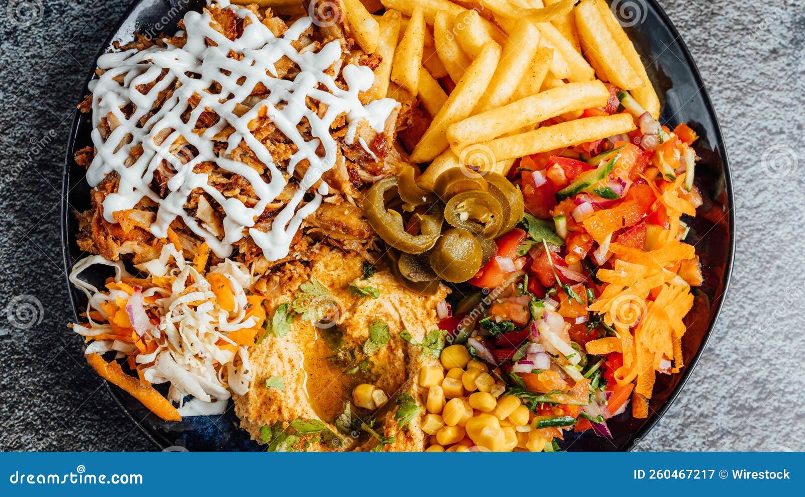 Top View of a Mixed Dish with Fries, Chicken, and Veggies Stock Image