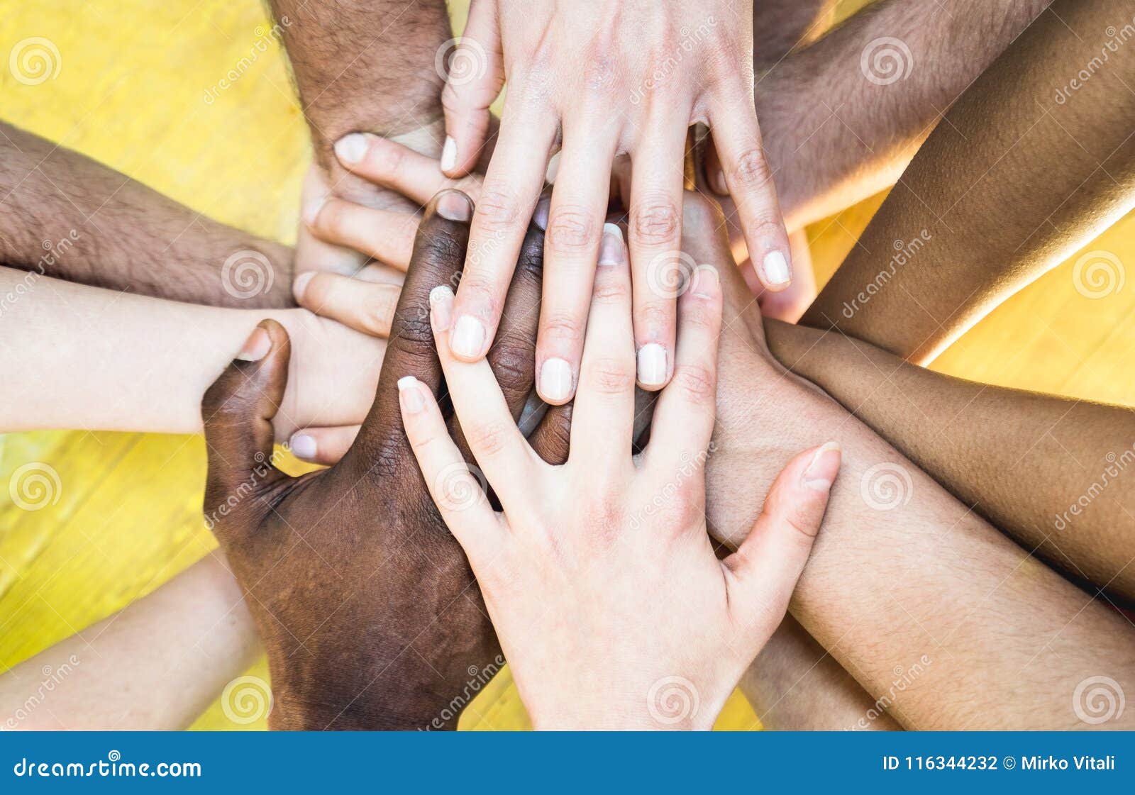 top view of multiracial stacking hands - international friendship