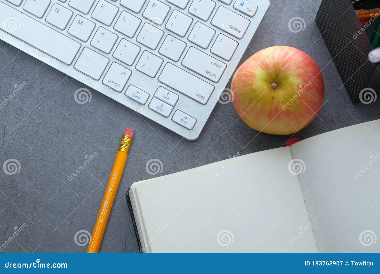 top view of open booms, apple and keyboard on gray background