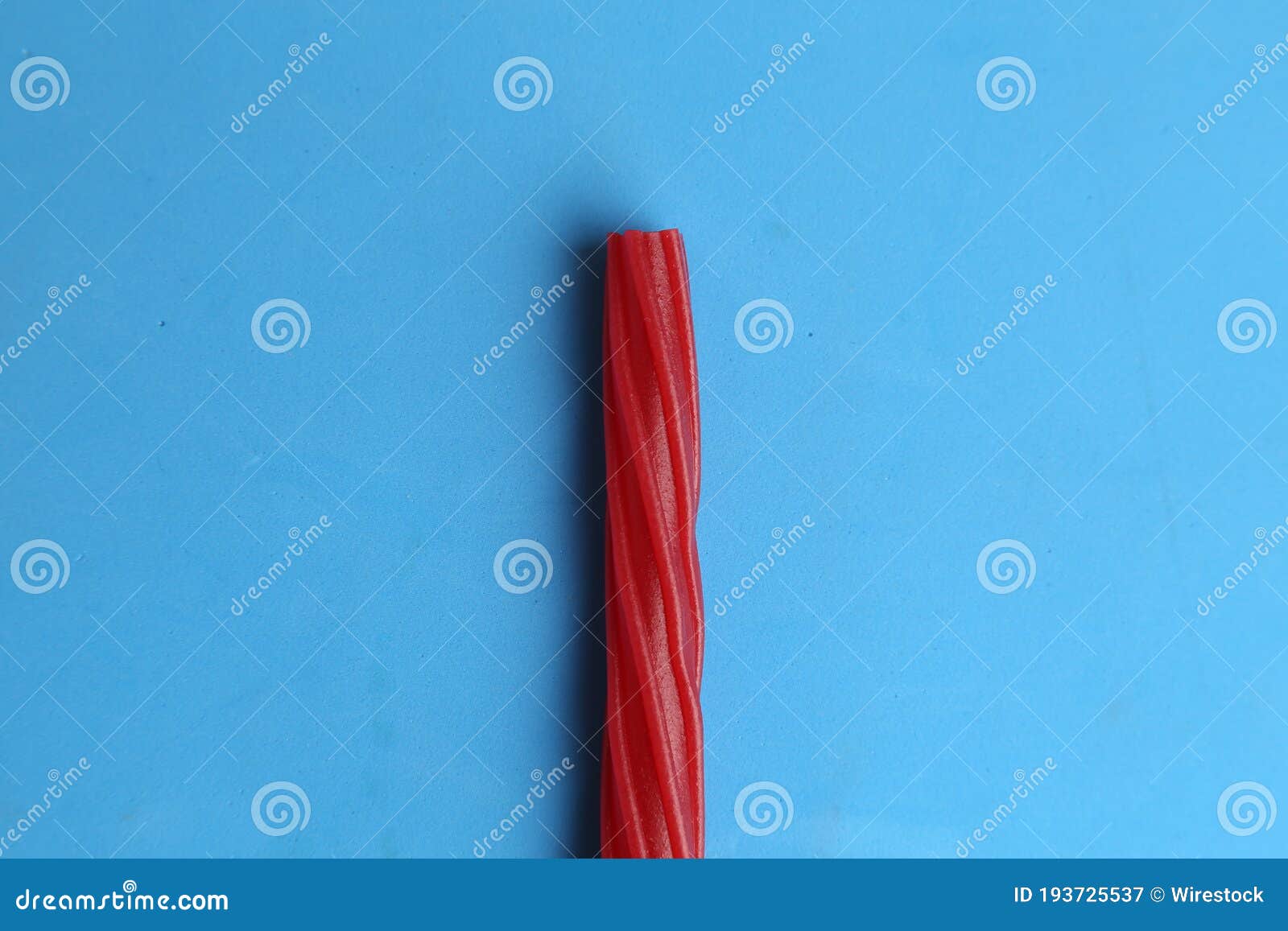 Top View of Red Gummy Licorice Stick on a Blue Background Stock Image