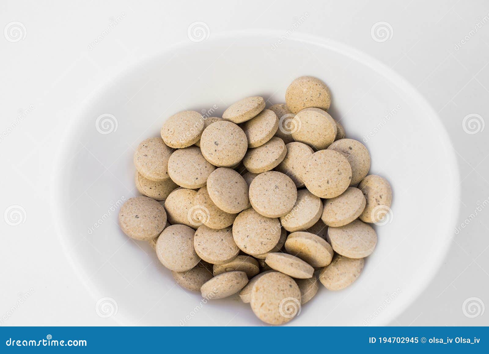 top view of round yellow tablets in a white cup