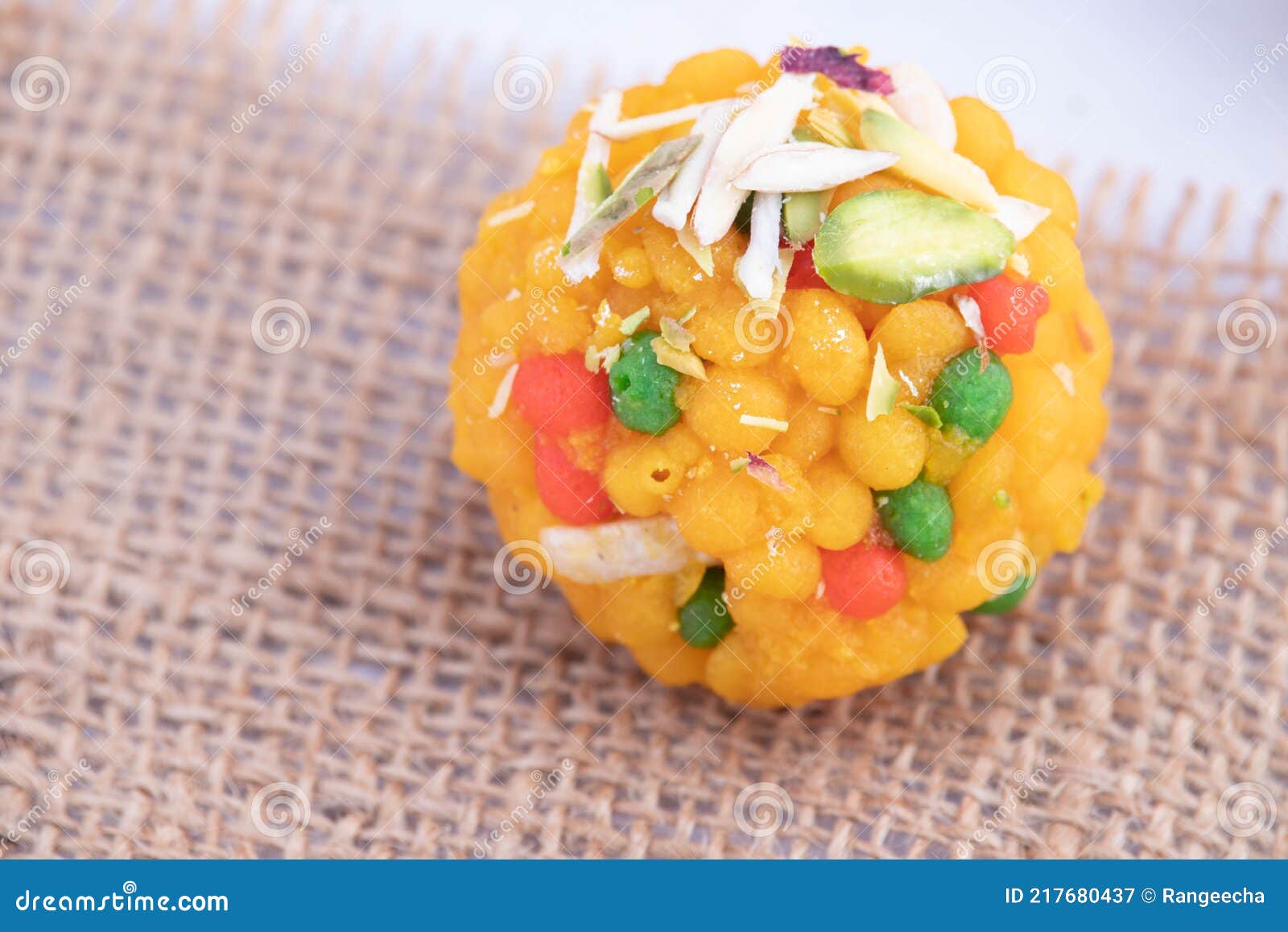 top view of single piece indian mithai jodhpuri ladoo laddu also called boondi or bundi ladoo on burlap jute fabric. meetha laddoo