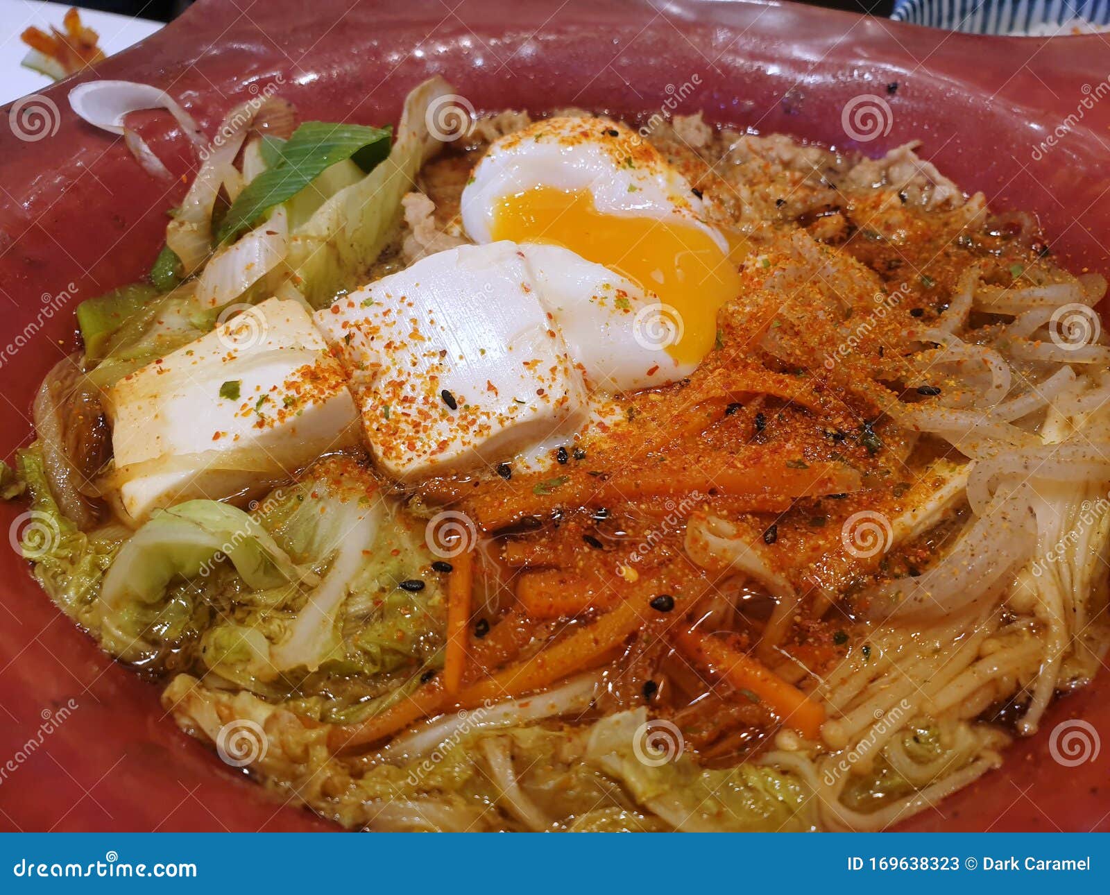 top view of small noodle without soup topped with boiled eggs and tofu