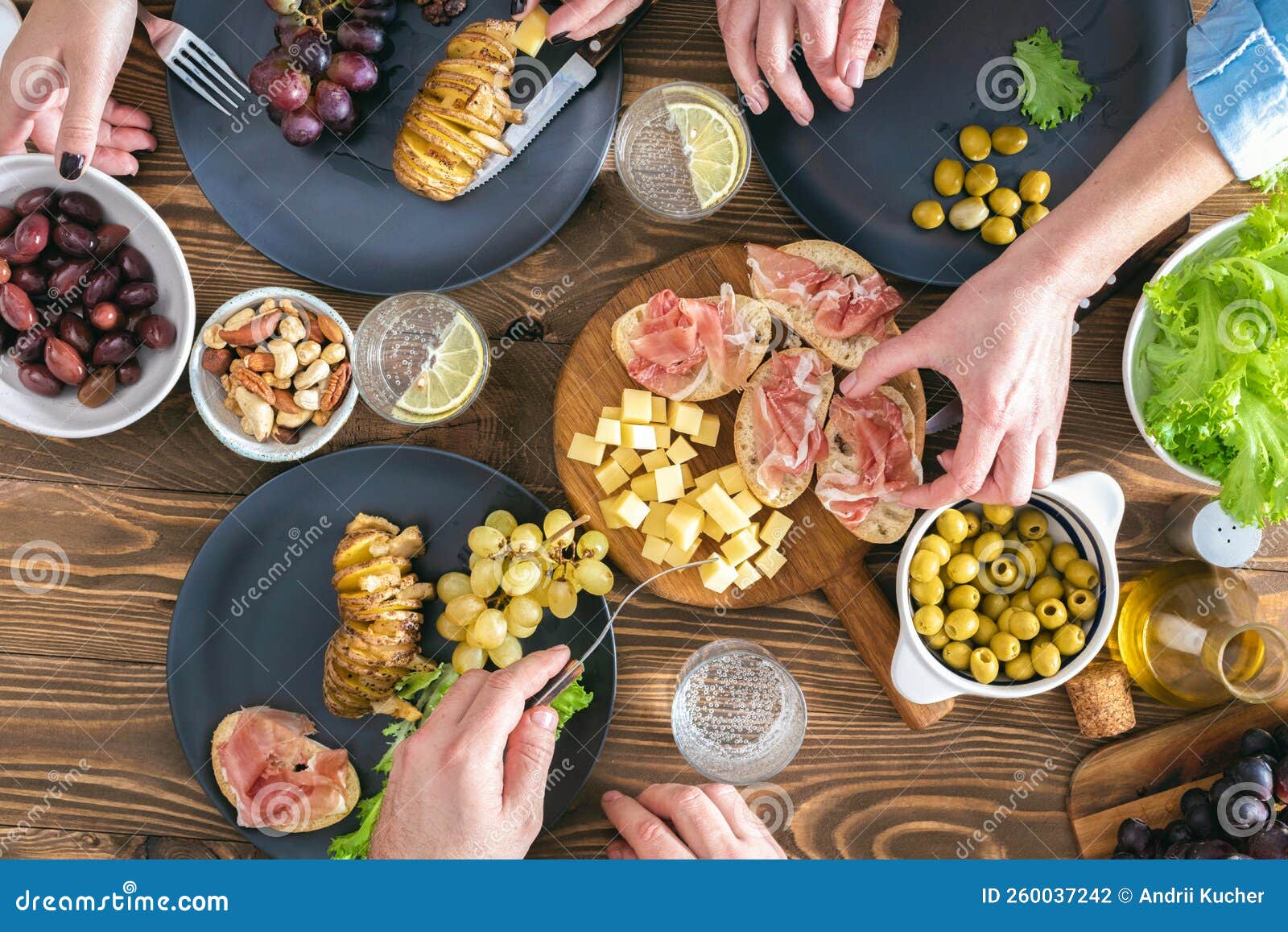 Top View of Three People Having Dinner Together on Rustic Wooden Table