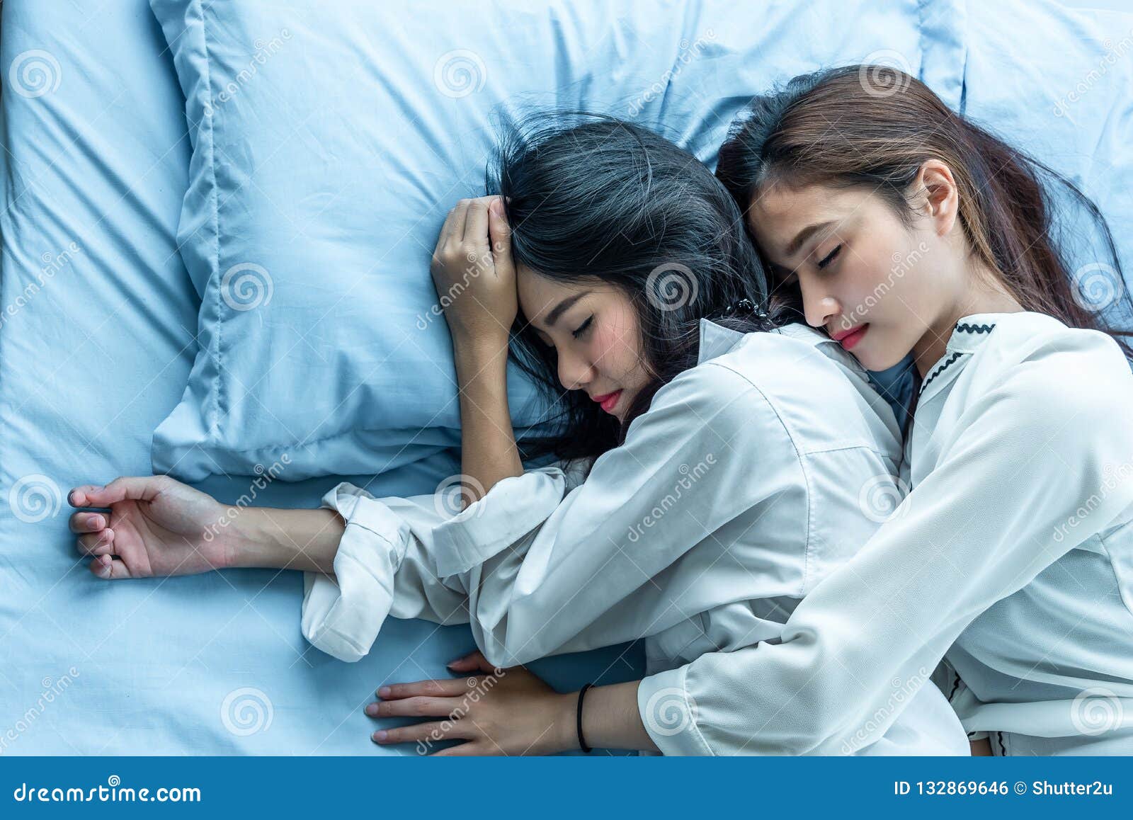 Top View of Two Asian Women Sleeping on Bed Together photo