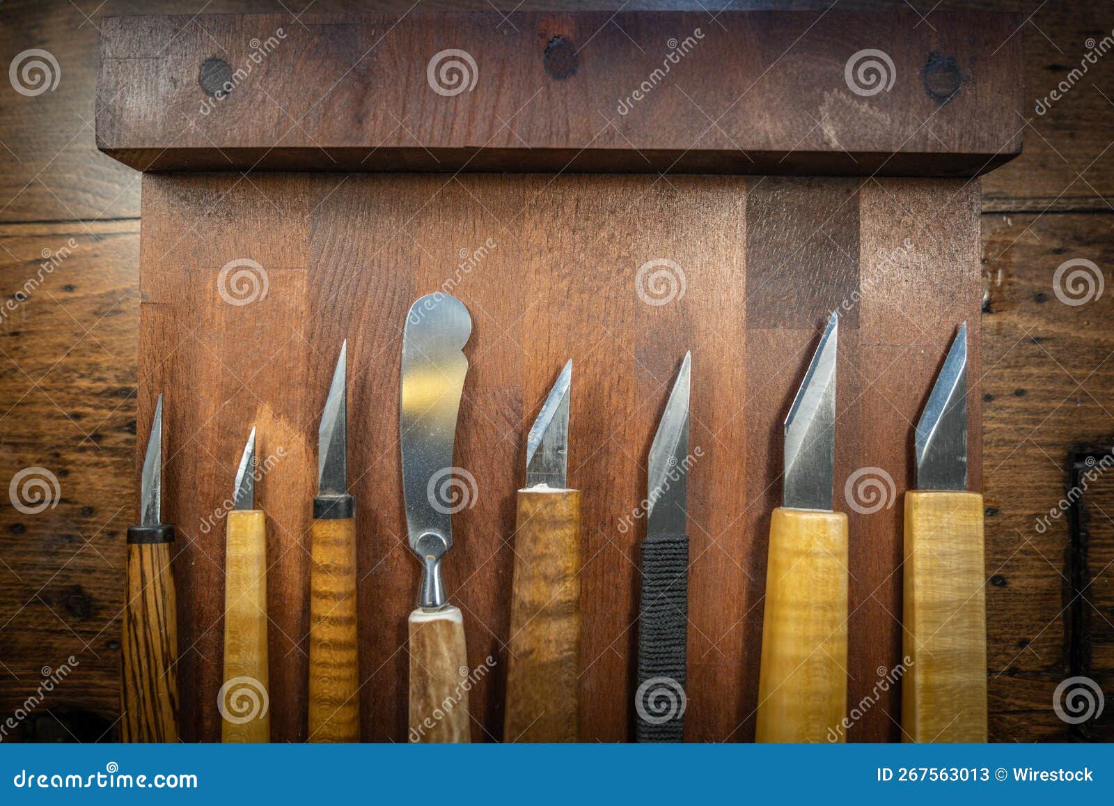 top view of wood carving and cutting tools for luthiery arranged on a wooden board