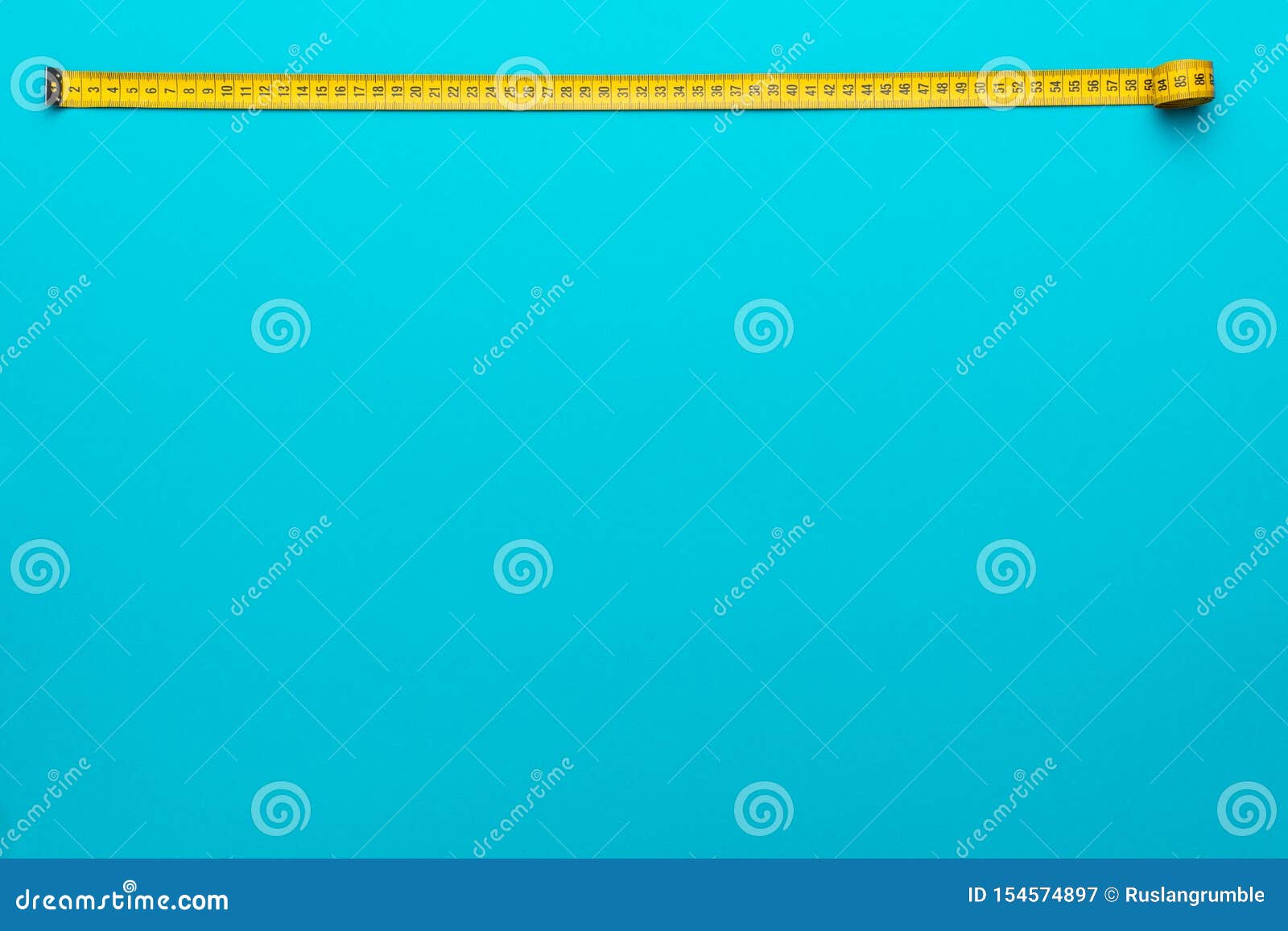 Top view of yellow soft measuring tape. Minimalist flat lay image