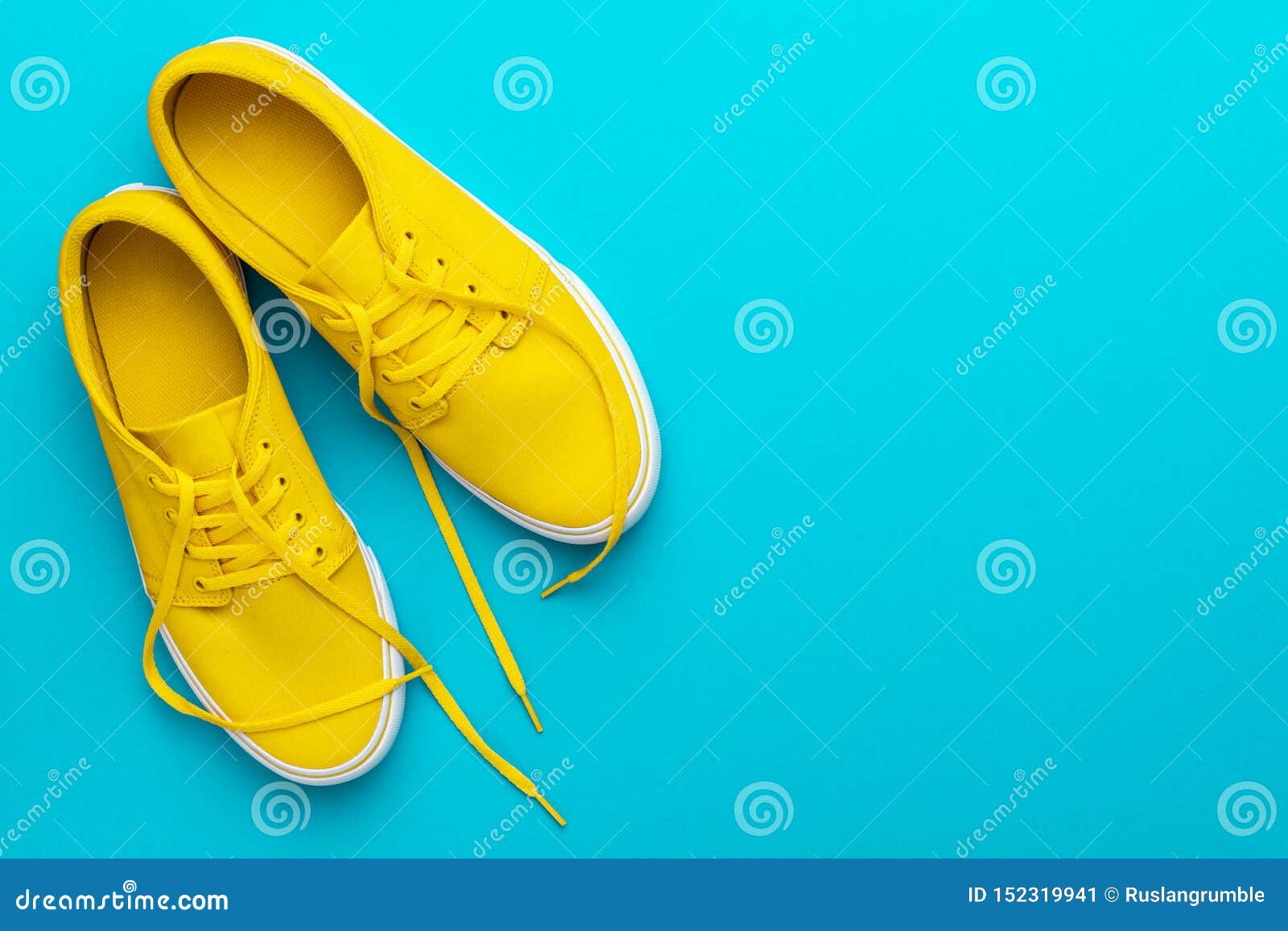 Top View of Yellow Untied Sneakers on Blue Turquoise Background with ...