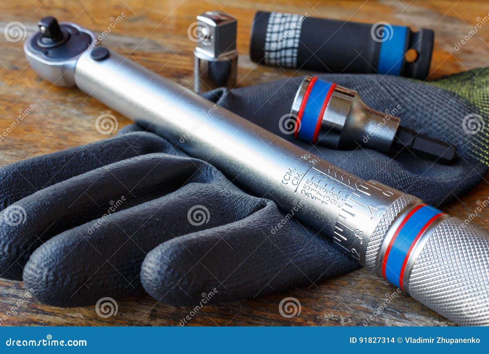 torque wrench with spanner heads and work glove on the table in a workshop