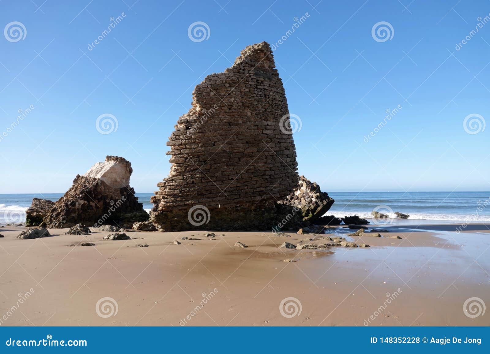 torre del loro mazagon remains at playa de rompeculos beach in mazagon, spain