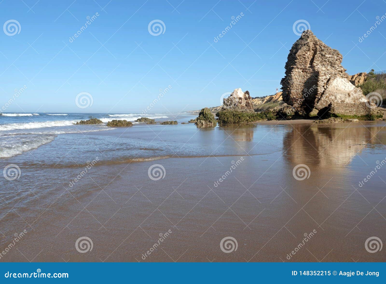 torre del loro mazagon ruins at playa de rompeculos beach in mazagon, spain