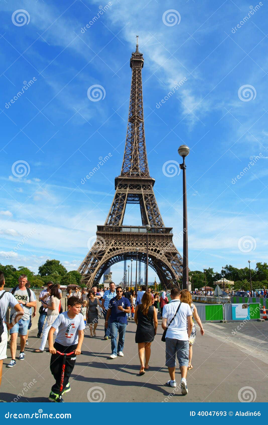 Torre Eiffel a Parigi. Parigi, Francia - 17 agosto 2013: la torre Eiffel (giro Eiffel) contro un cielo blu di estate a Parigi, Francia. È stata costruita fra 1887 e 1889 per la fiera del mondo (Expo 1889). Qualche gente intorno.