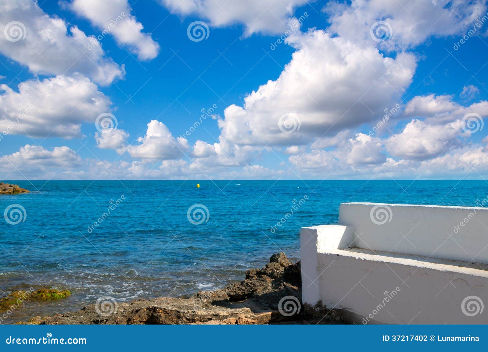 torrevieja alicante white bench in the shore rocks