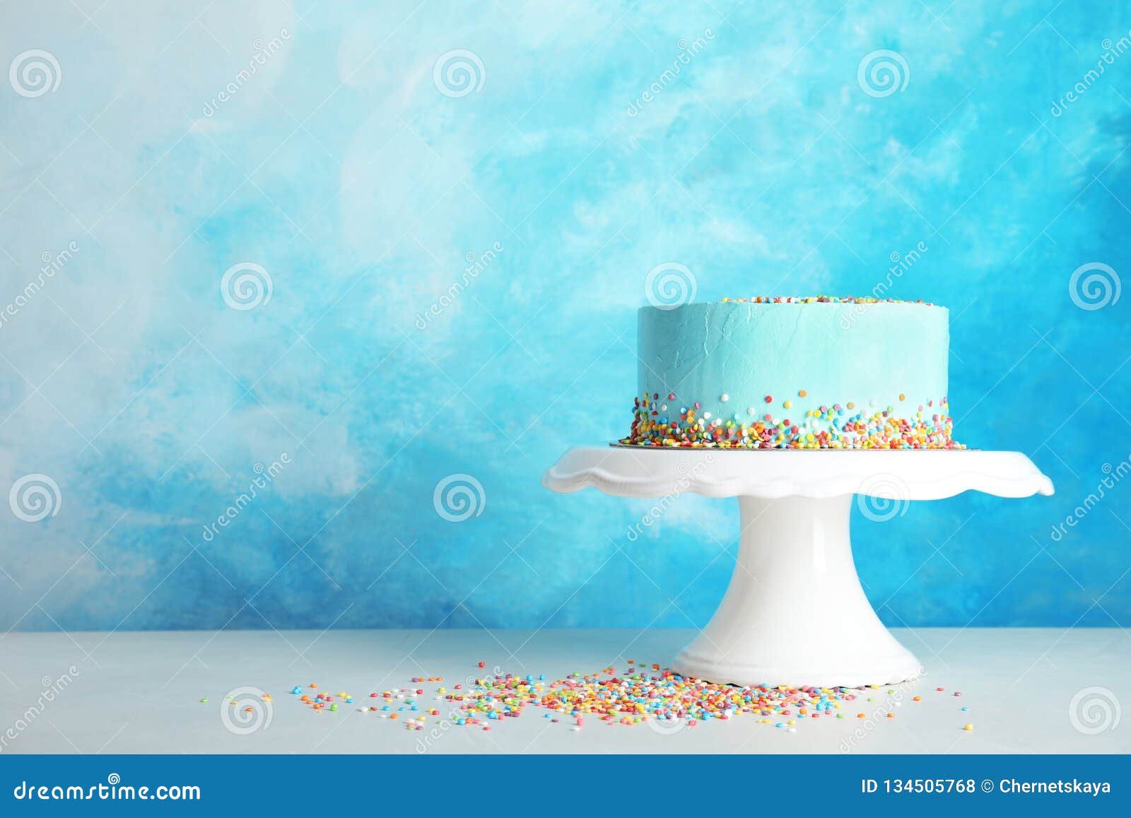 Torta de cumpleaños deliciosa fresca en soporte contra fondo del color Espacio para el texto