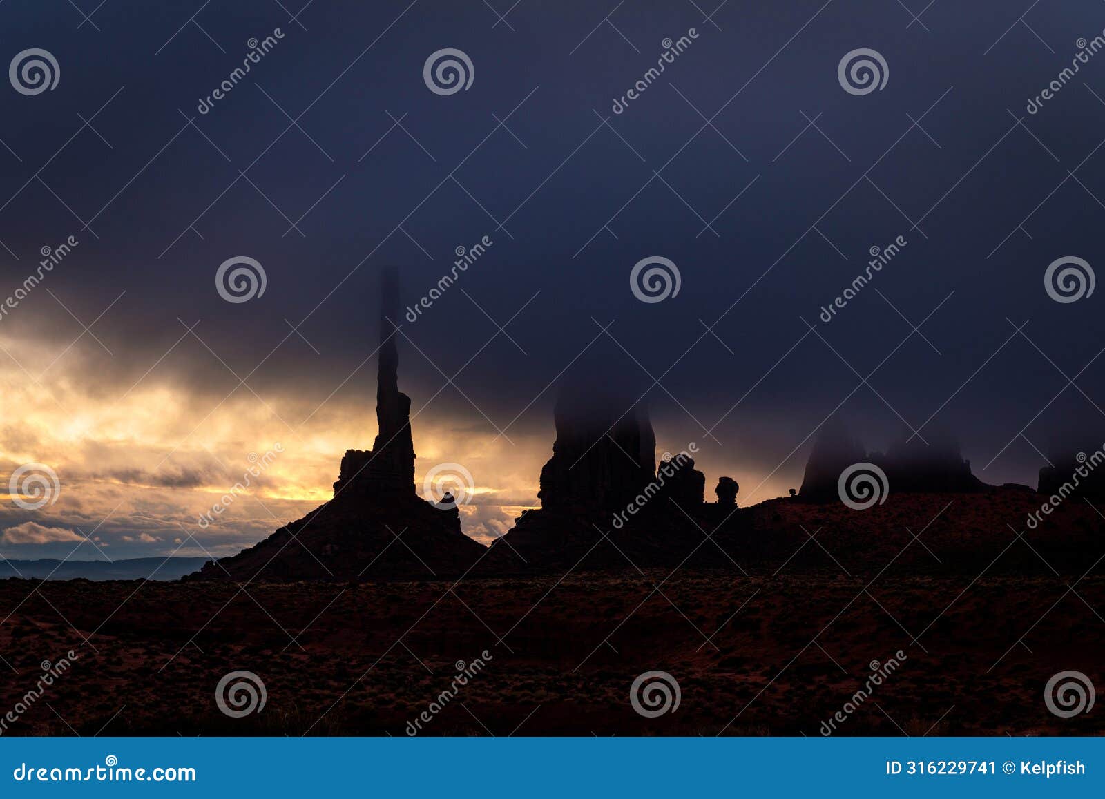 totem pole in monument valley during morning storm