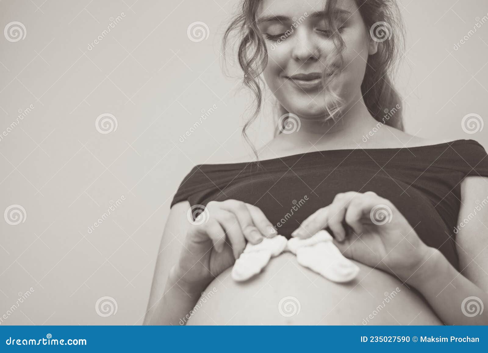 Touching Photo of Pregnancy Moments Young Expectant Mother with Socks on  Her Belly Stock Photo - Image of home, baby: 235027590