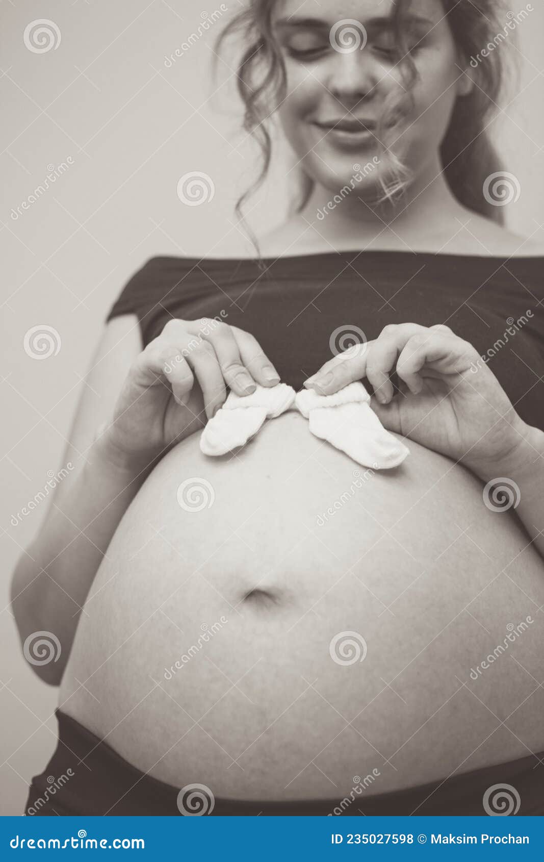 Touching Photo of Pregnancy Moments Young Expectant Mother with Socks on  Her Belly Stock Photo - Image of lifestyle, love: 235027598