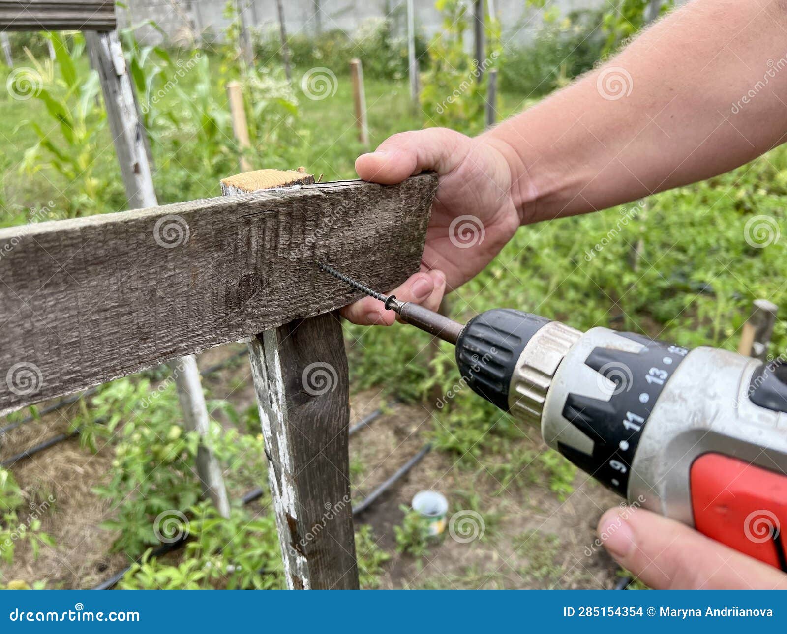 A Tough Construction Worker Applies Wooden Siding To a Garage and ...