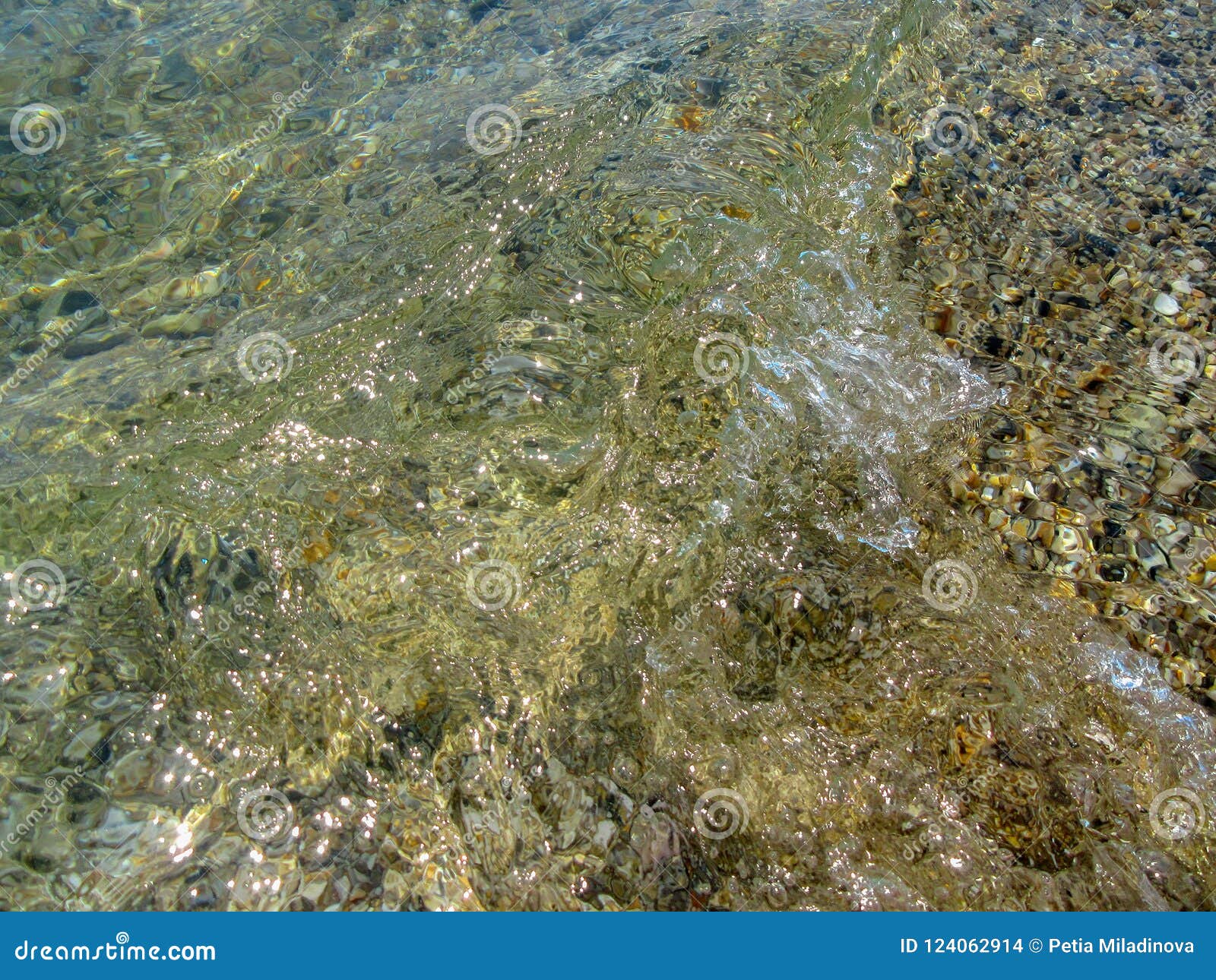 Tourbillon de l'eau de mer transparente au-dessus des cailloux multicolores. Texture de nature Par la côte de la mer Égée