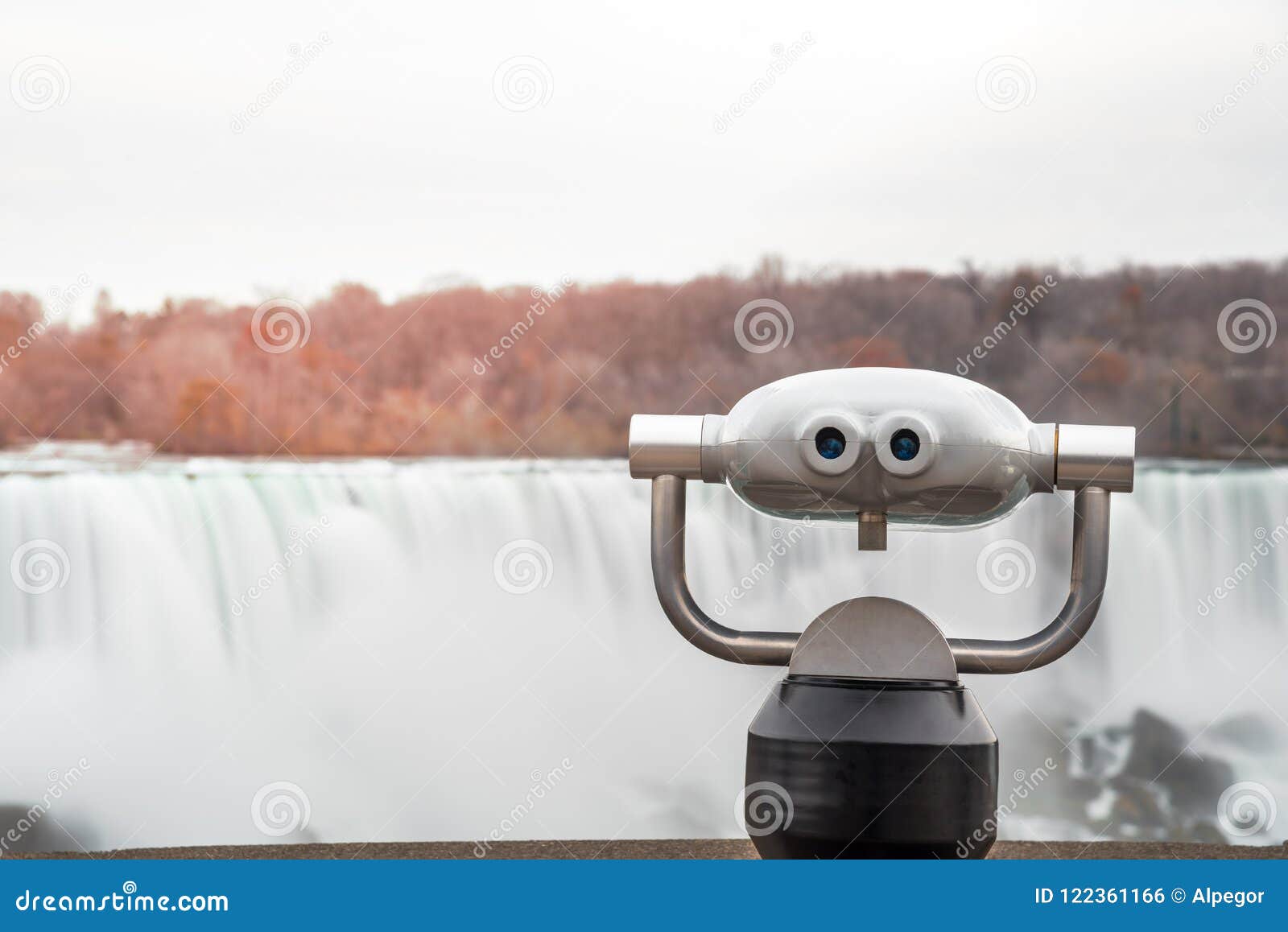 tourist binocular with a waterfall in background at sunset
