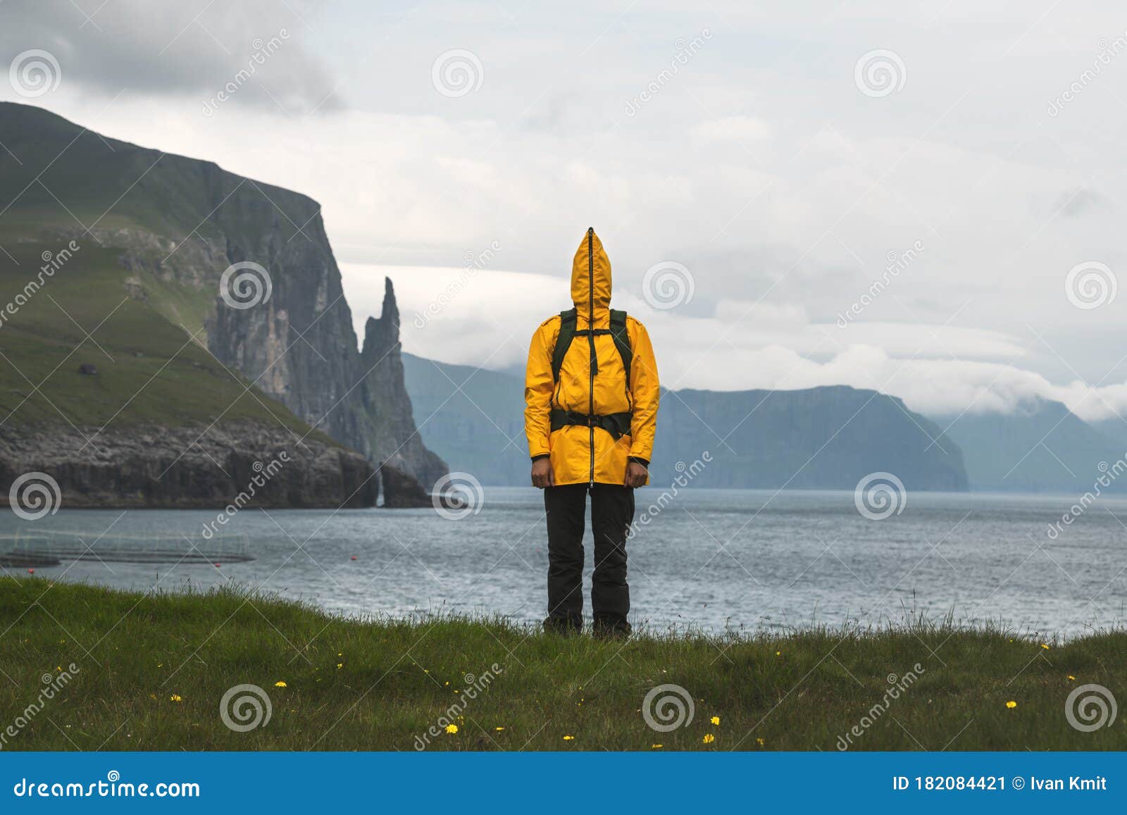 tourist in funny yellow jacket at trollkonufingur viewpoint