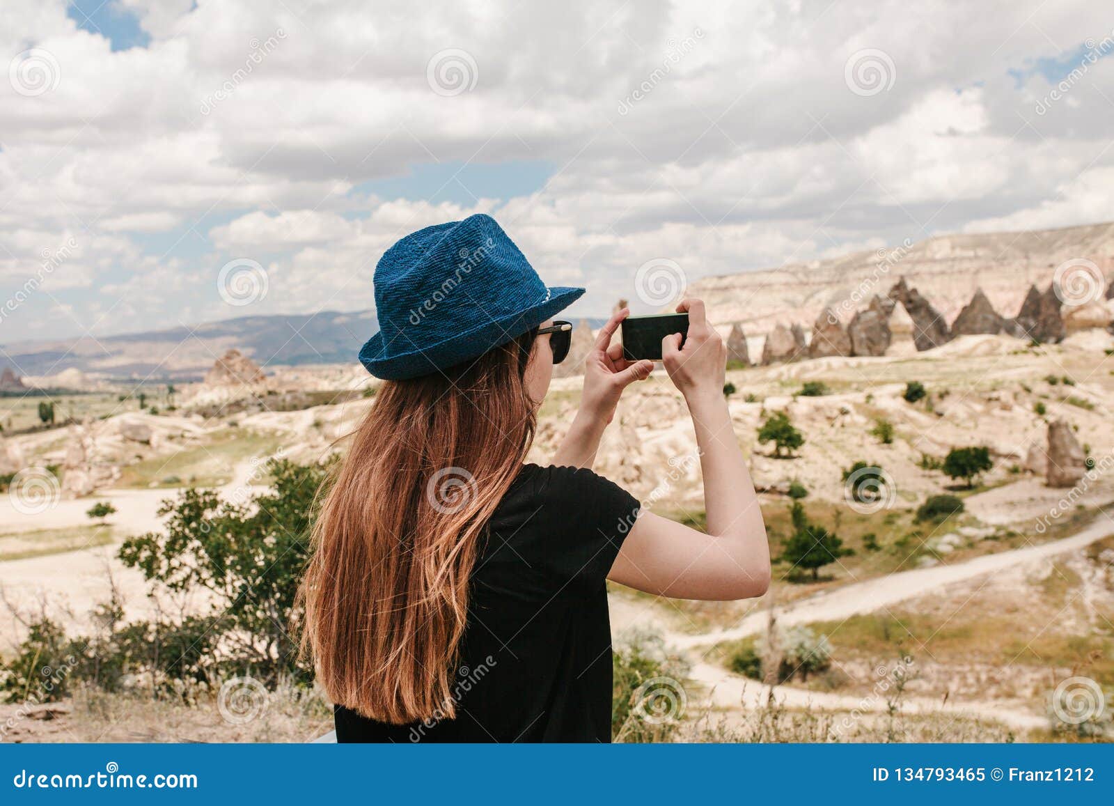 a tourist makes a photo on the phone in memory of a beautiful view of the hills in cappadocia in turkey. travel, tourism