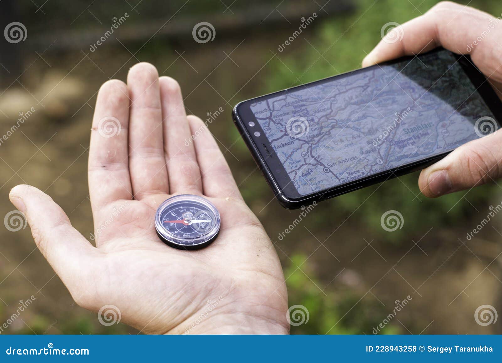 A Tourist Navigates Terrain Holding a Compass and a Smartphone with Map Concept Tourism Travel Stock Photo - Image device, navigation: 228943258