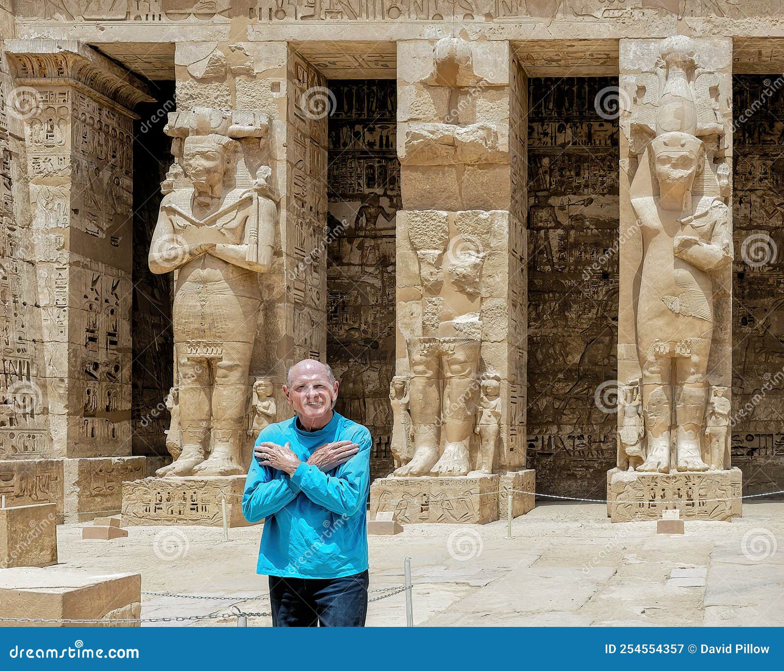 tourist & osiride statues of ramesses iii being attended to by little queens on the right side of the first court of his temple.