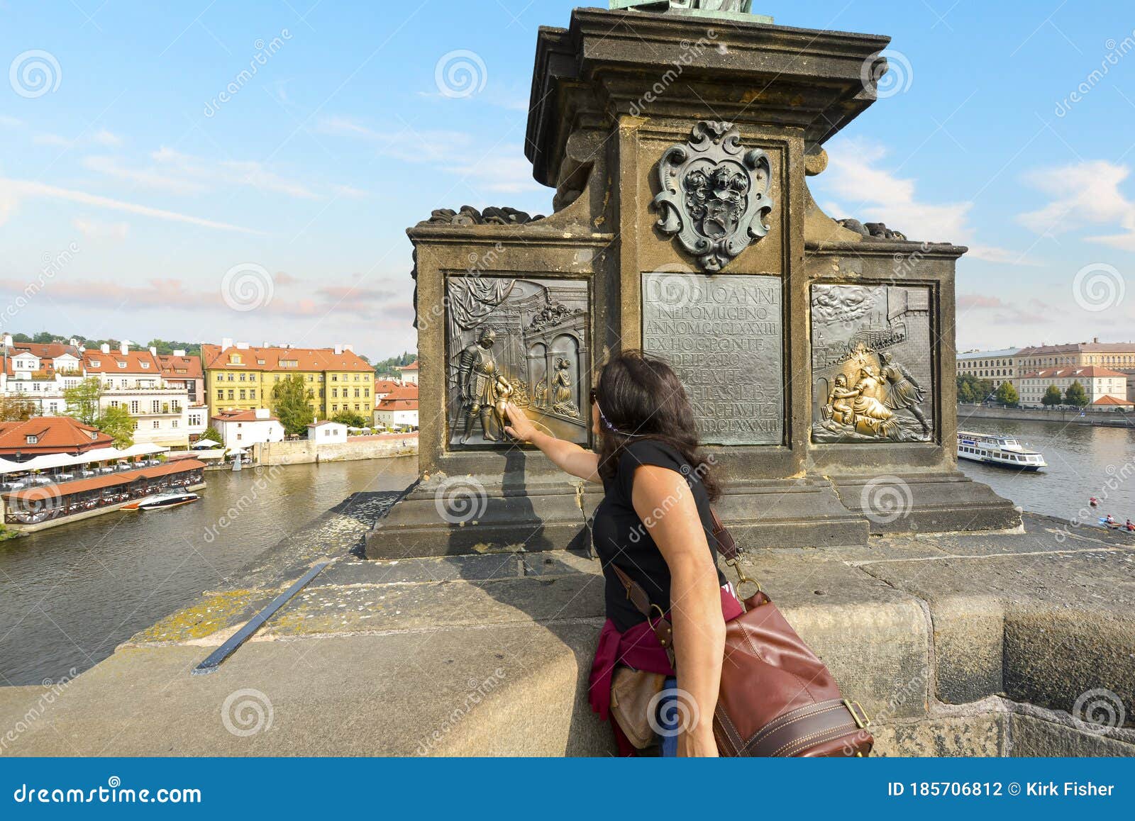 A Tourist Rubs The Bronze Plaque On The Statue Of Saint
