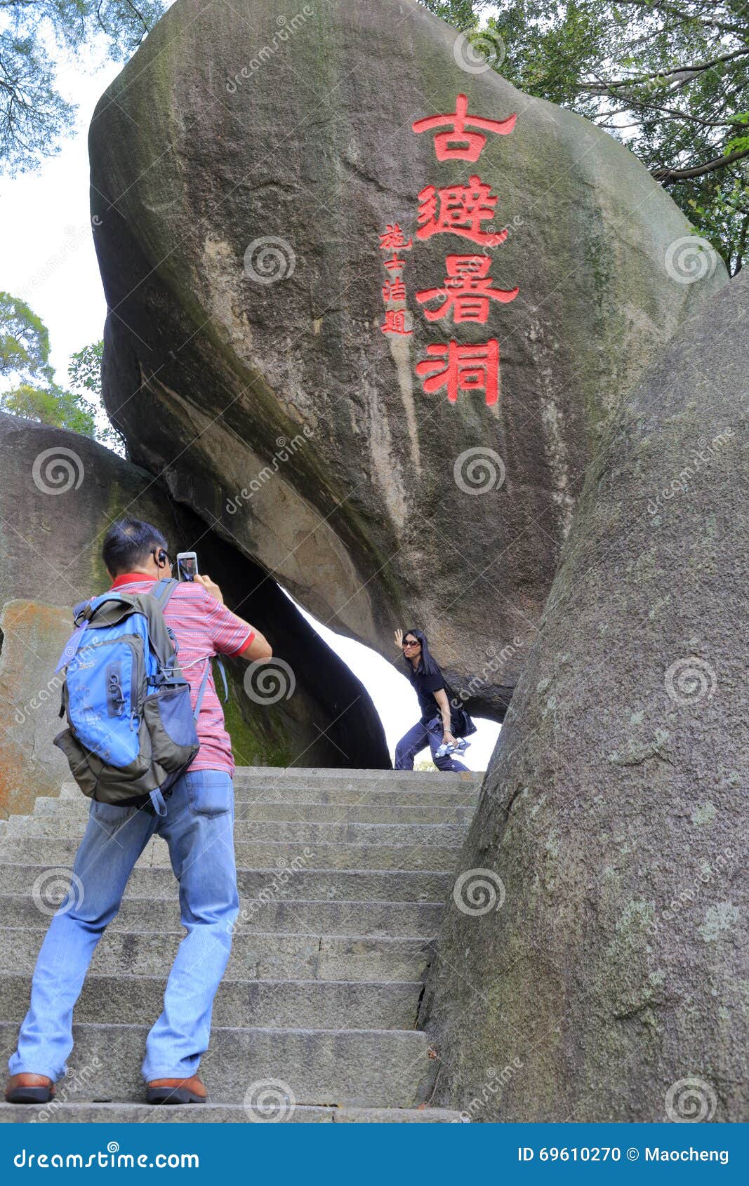 Tourist take photo at ancient summer hole, gulangyu island, china. At gulangyu, there is a megalithic quartet built ancient summer hole. the granite cave is bright, airy, cool. in fact, they are due to wave erosion formed by sea erosion.