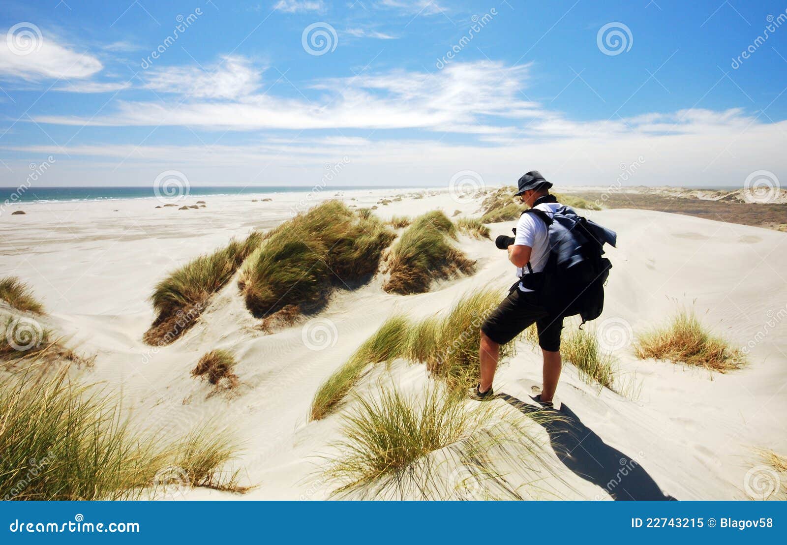 tourist taking photo of farewell spit sand dunes