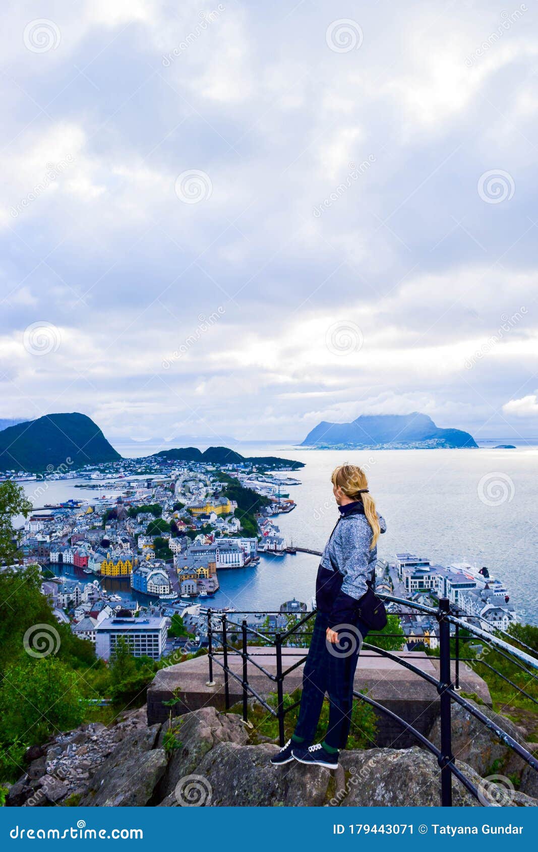 tourist woman looks on the alesund cityscape from aksla viewpoint. norway