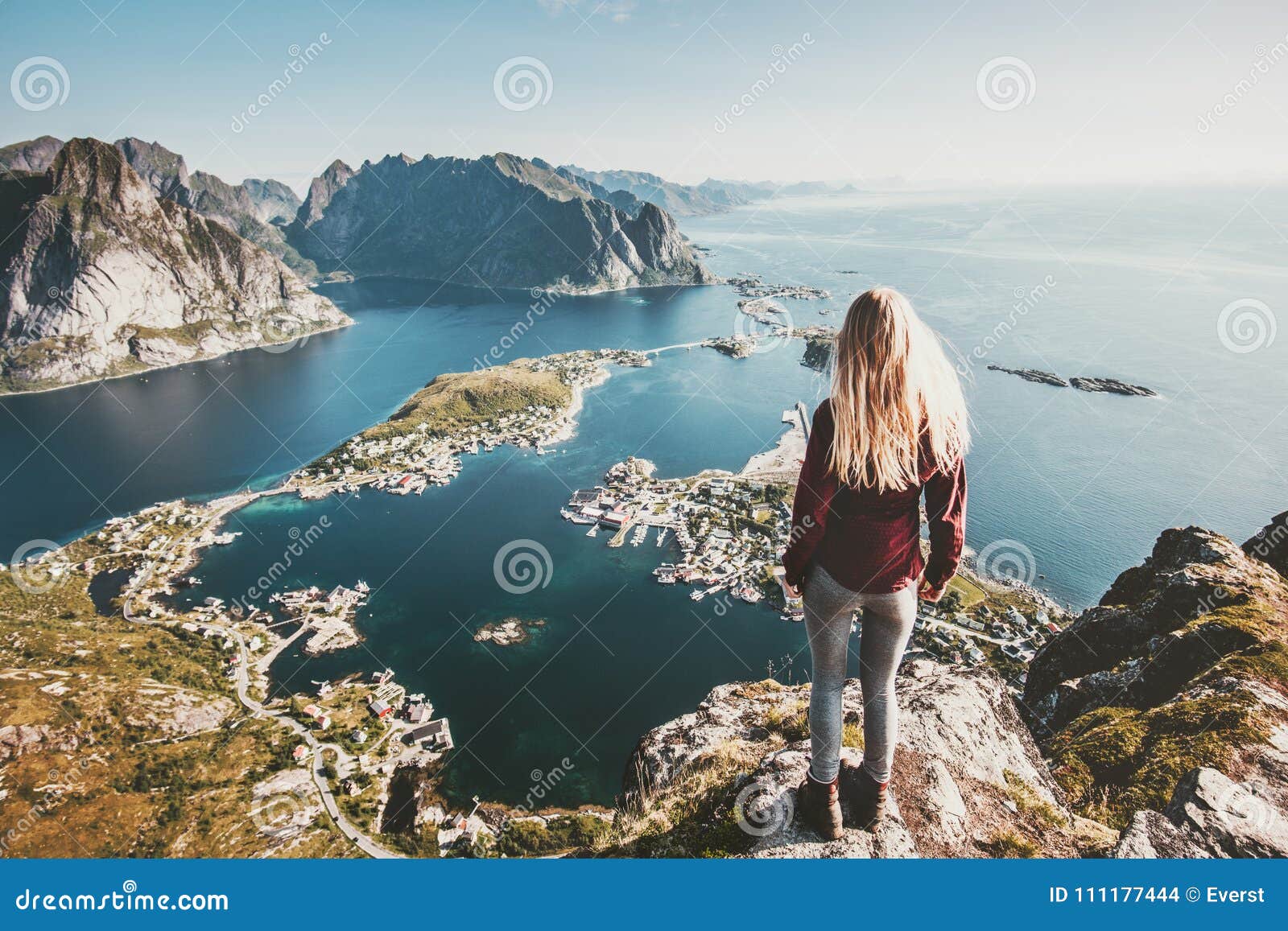 tourist woman standing on cliff of reinebringen mountain aerial view