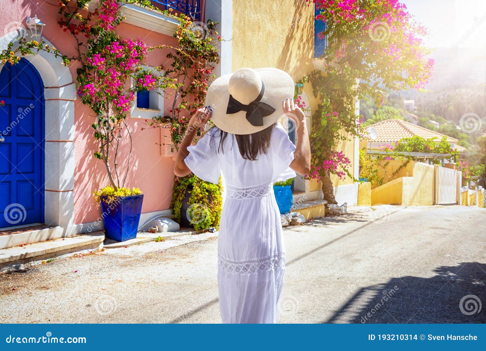 a woman in a white summer dress walks down the colorful streets of the little village assos, kefalonia, greece