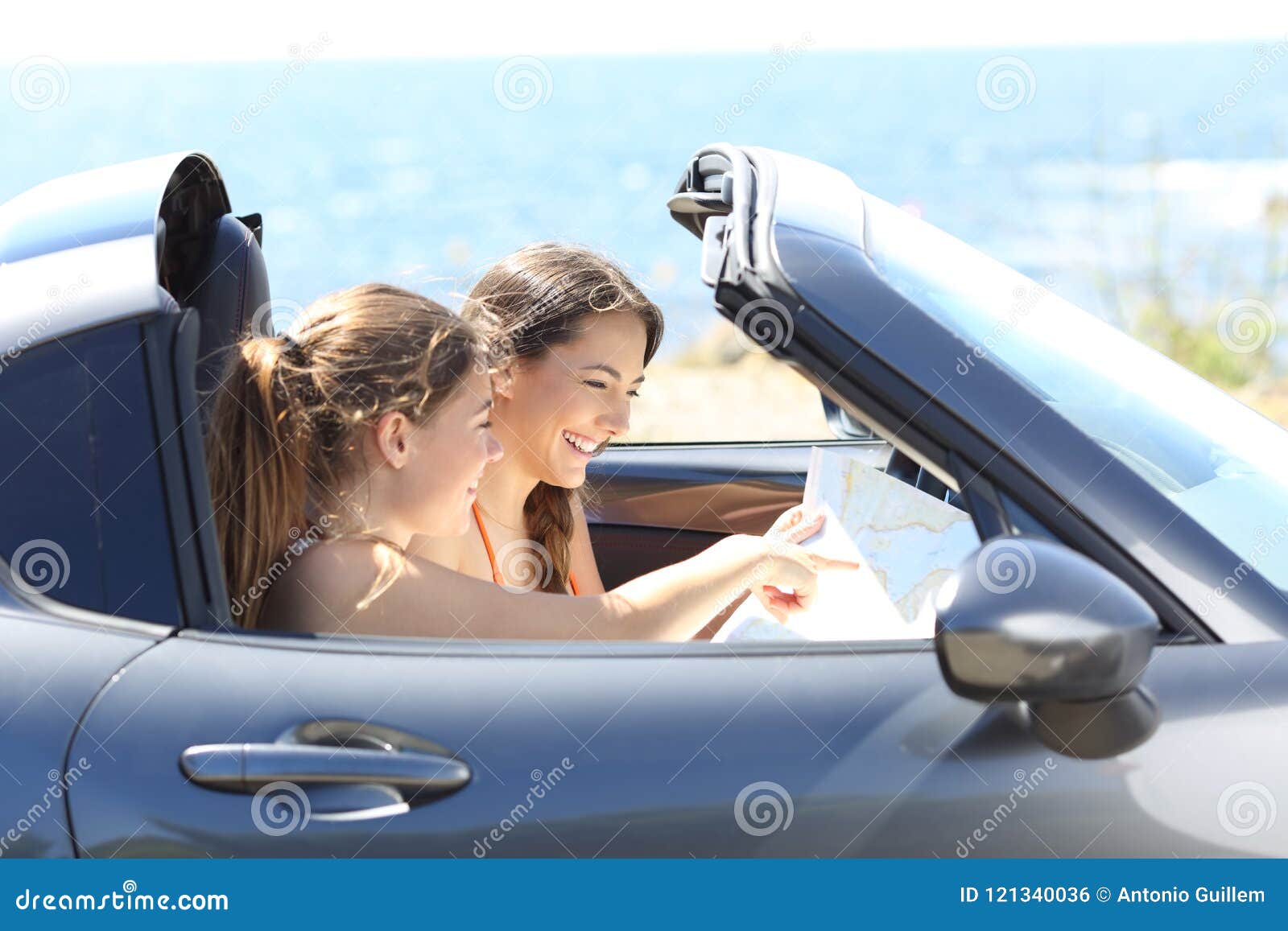 Tourists Checking Guide Inside a Car on Vacations Stock Photo Image