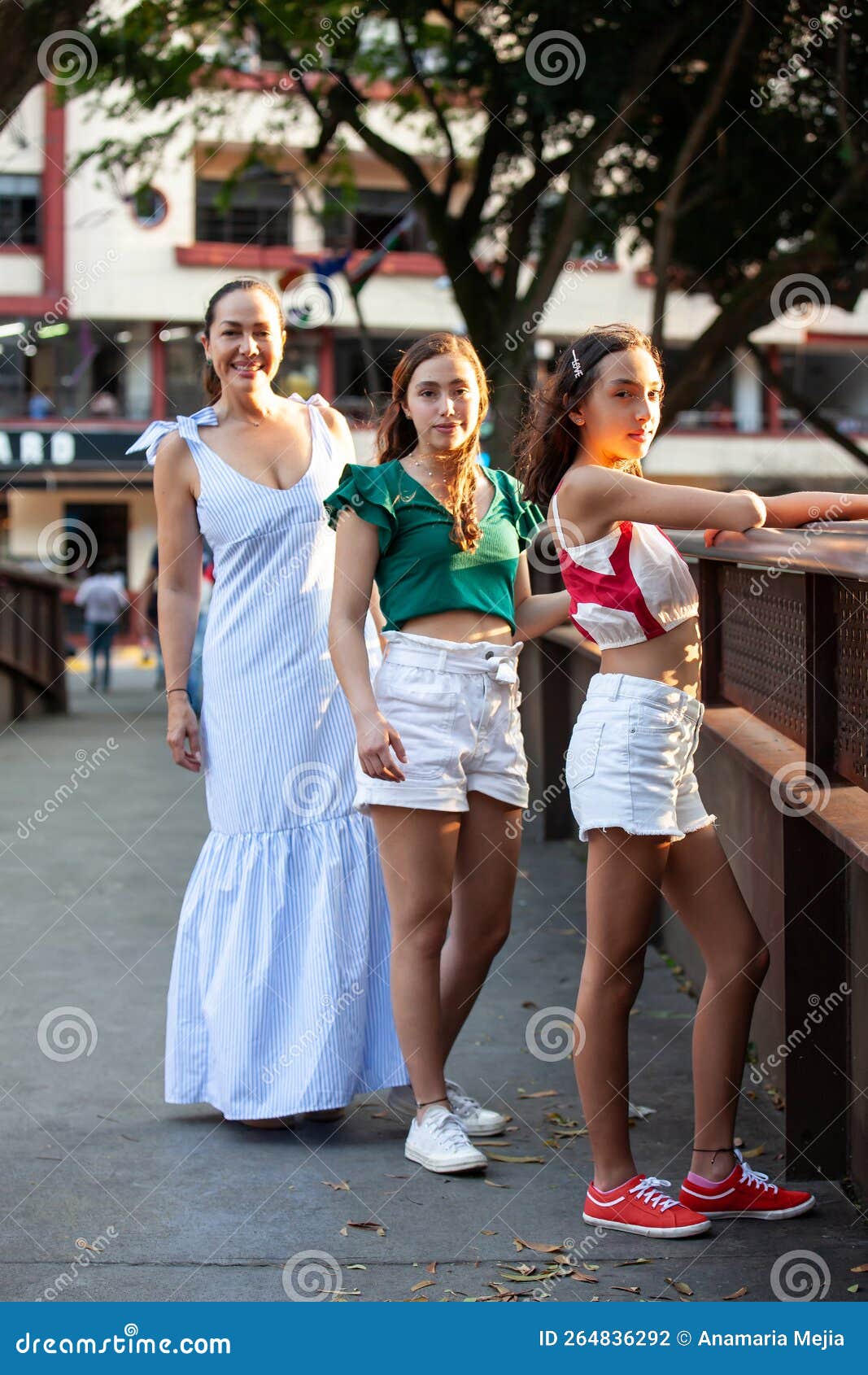 tourists at one of the bridges along the cali river boulevard in the city of cali in colombia. mother and teenager daughters